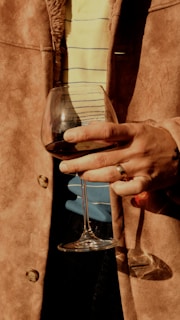 A person holding a wine glass in their hand