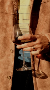 A person holding a wine glass in their hand