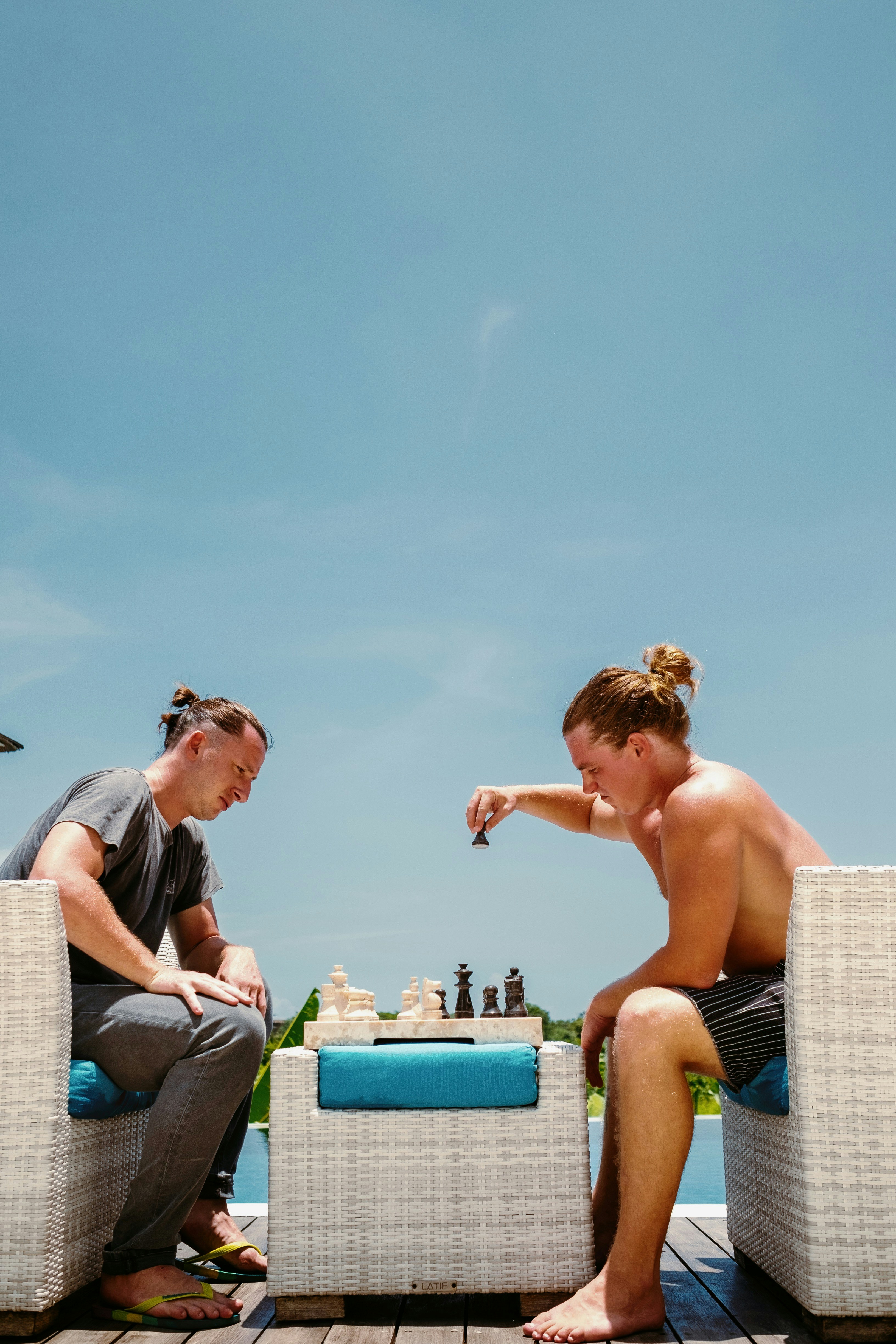 A man and a woman playing chess on a deck