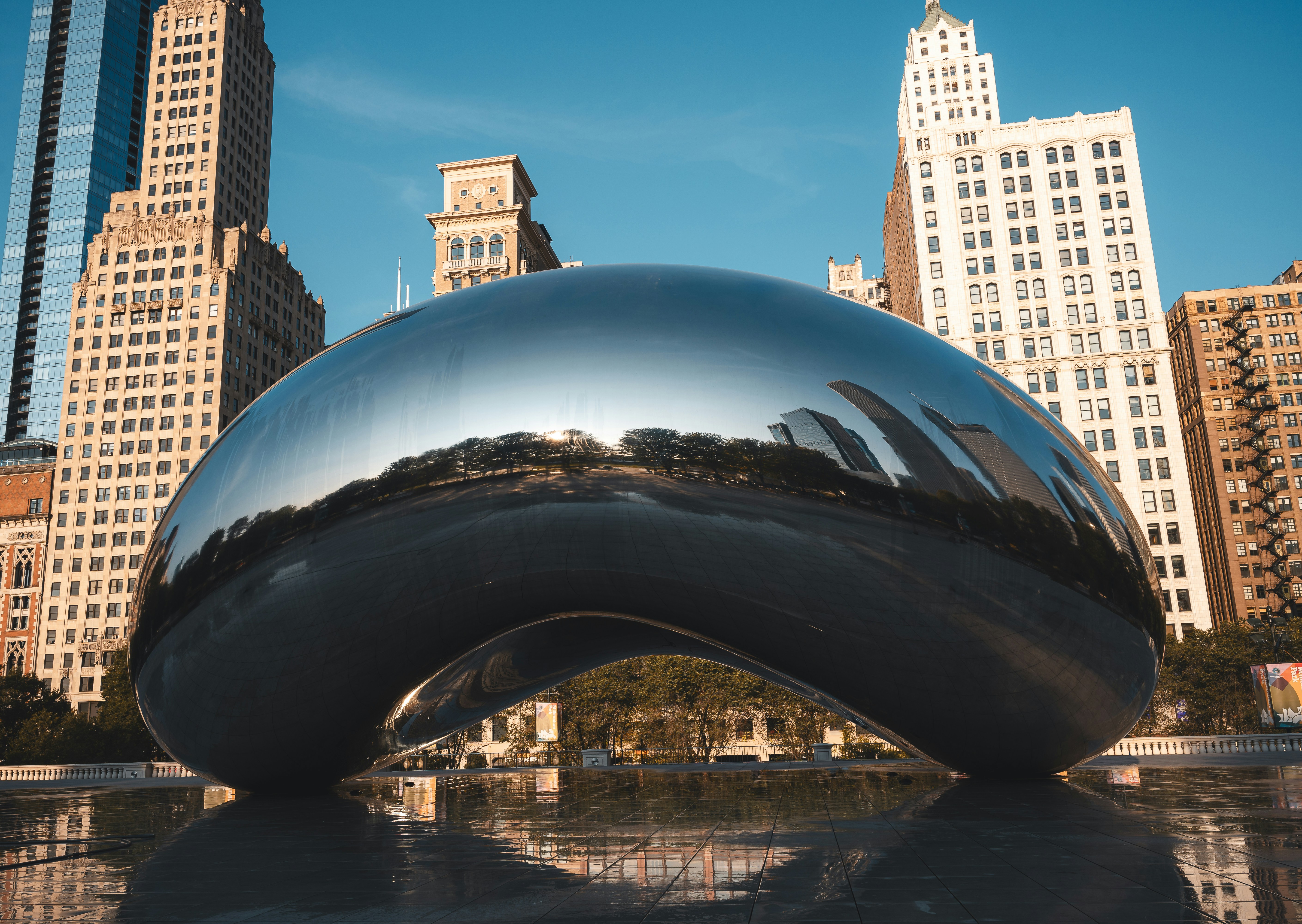 A large metal sculpture in front of a city skyline