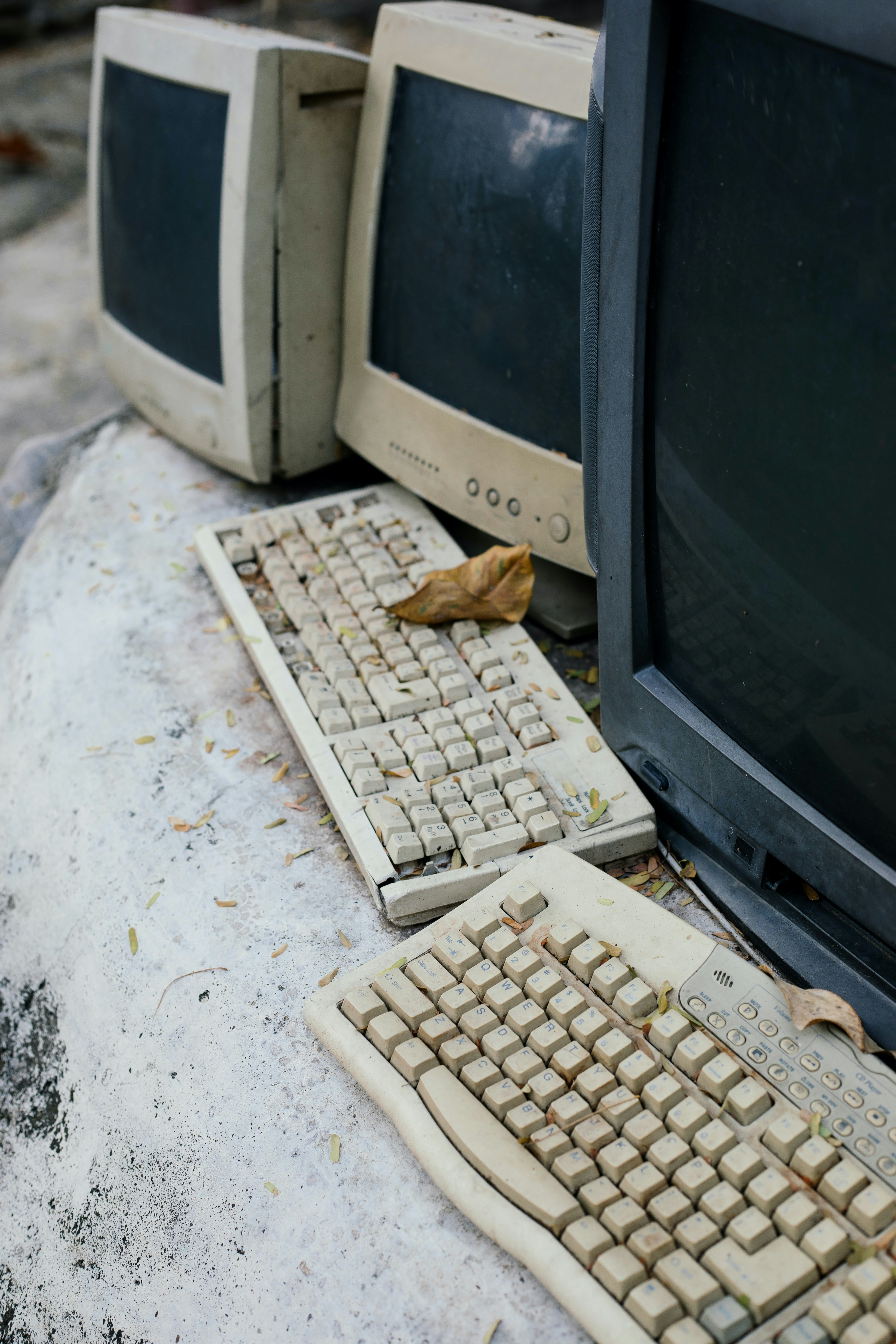 Abandoned keyboard and monitors outdoors.