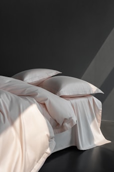 A bed with a white comforter and pillows