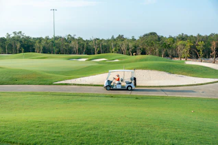 A golf cart driving down a golf course