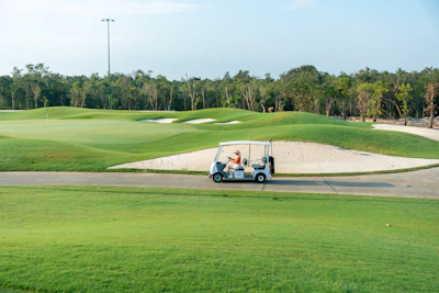 A golf cart driving down a golf course