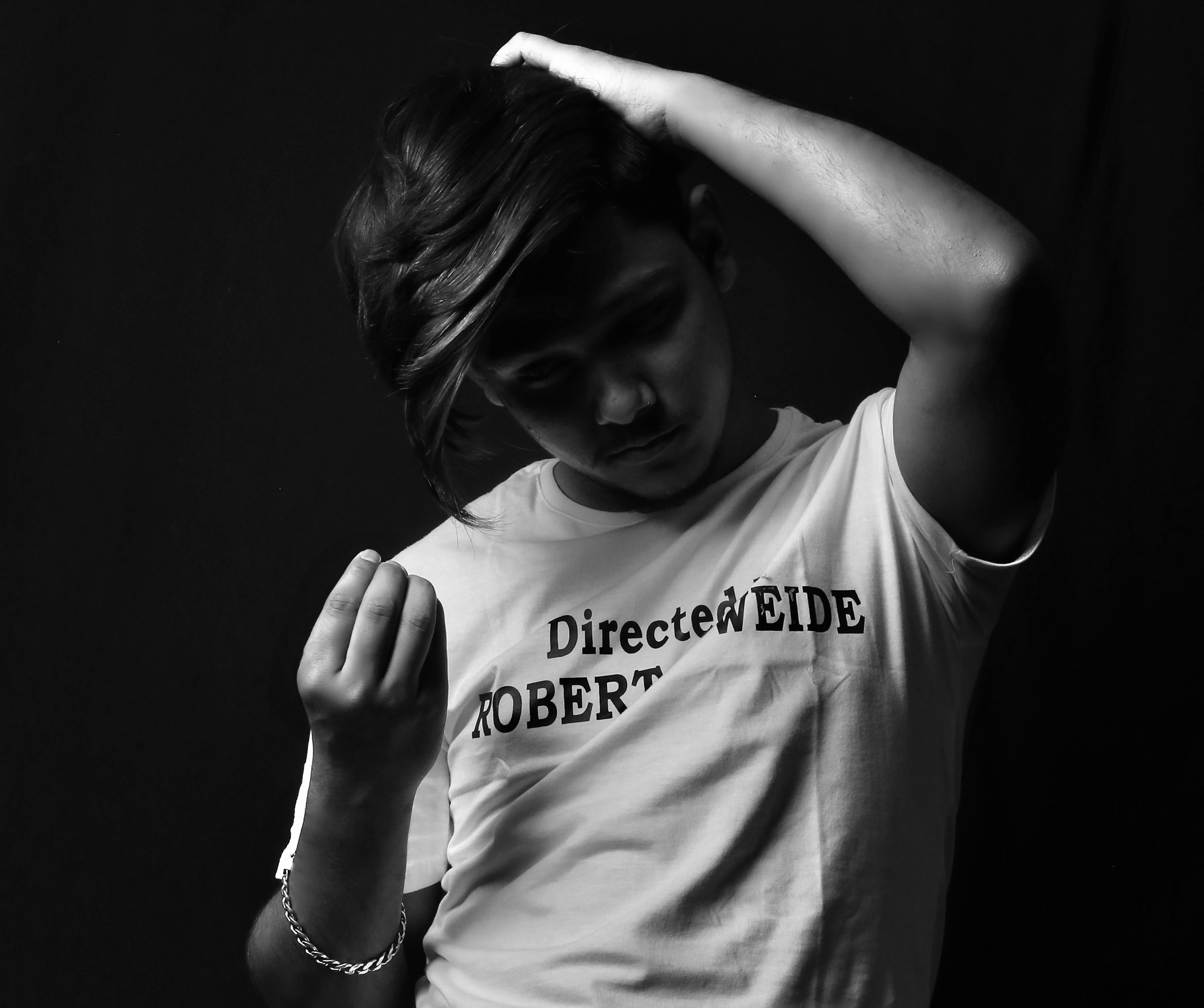 白いシャツを着た女性が髪を押さえています