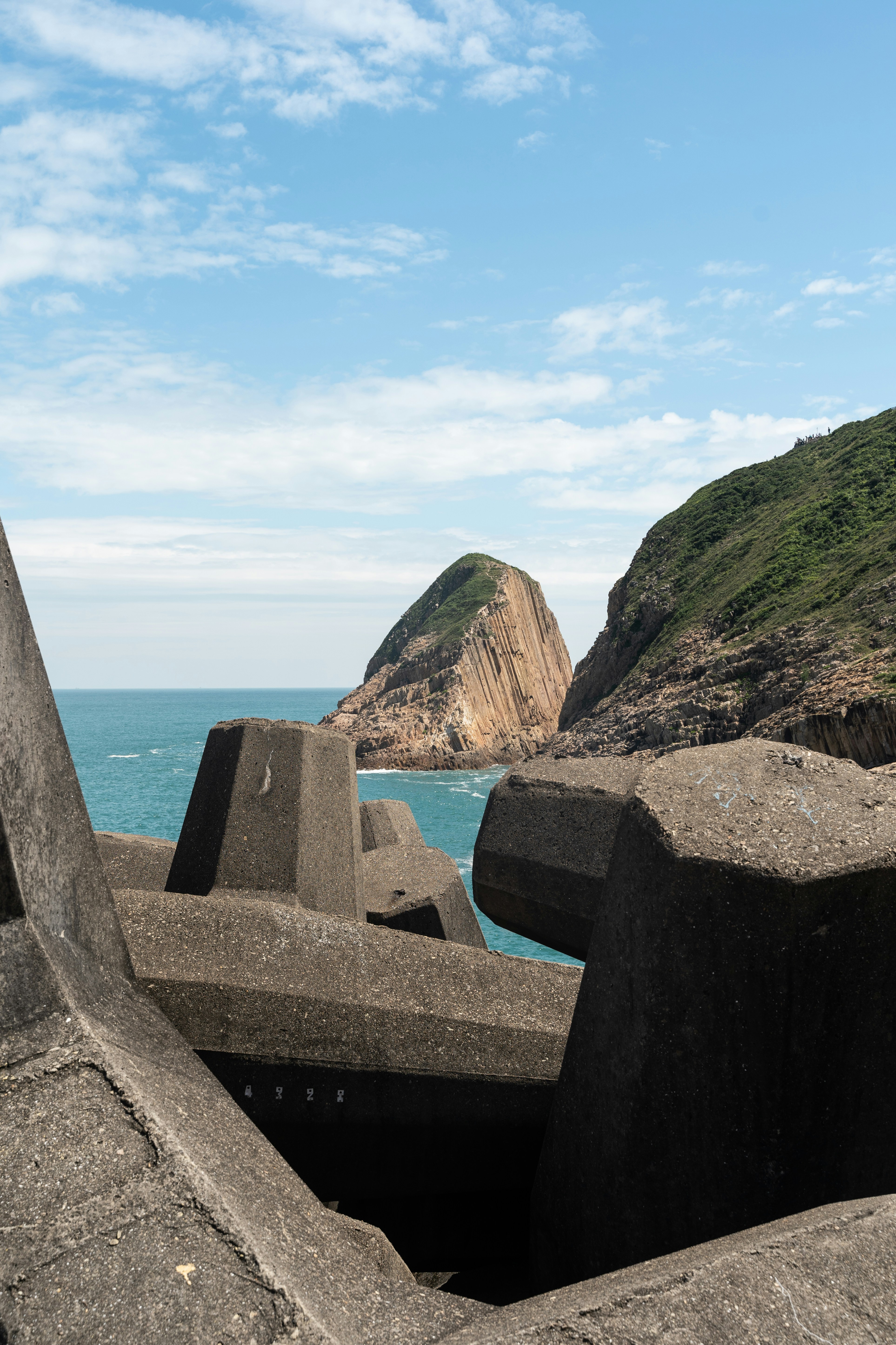 A bench sitting on top of a cement wall next to the ocean