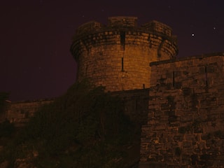 A very tall castle with a clock on it's side