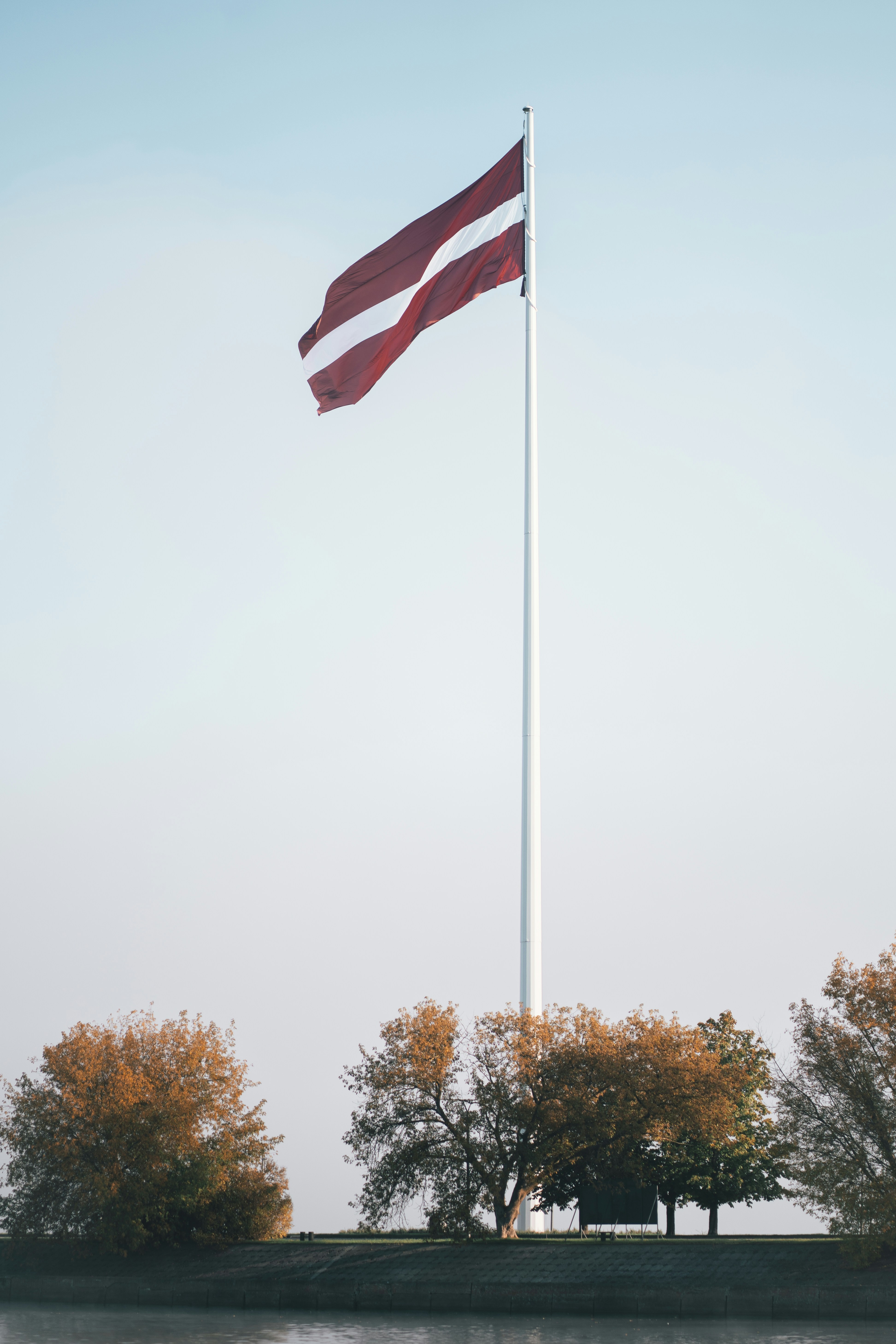 A large flag flying over a body of water