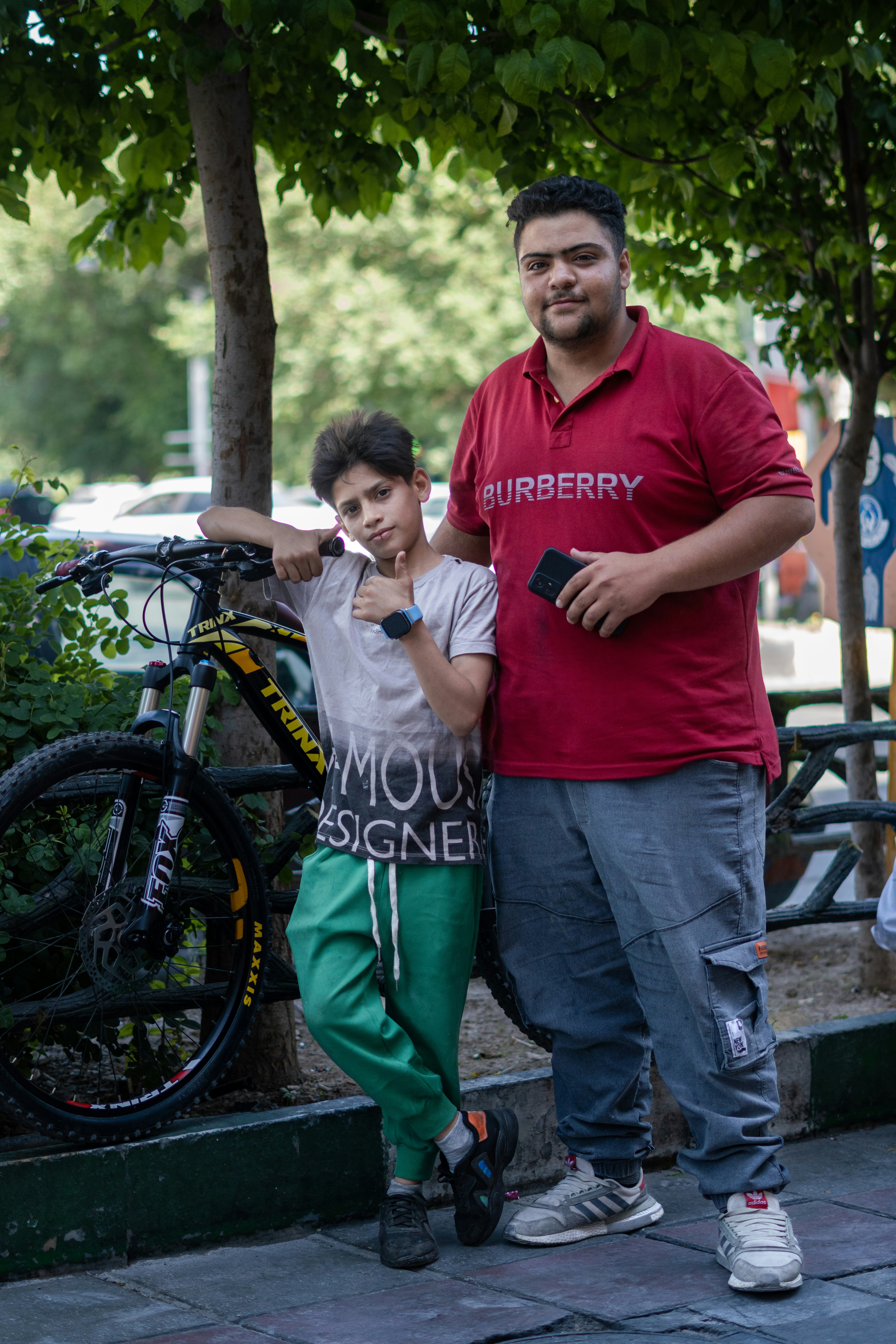 A man standing next to a boy next to a bike