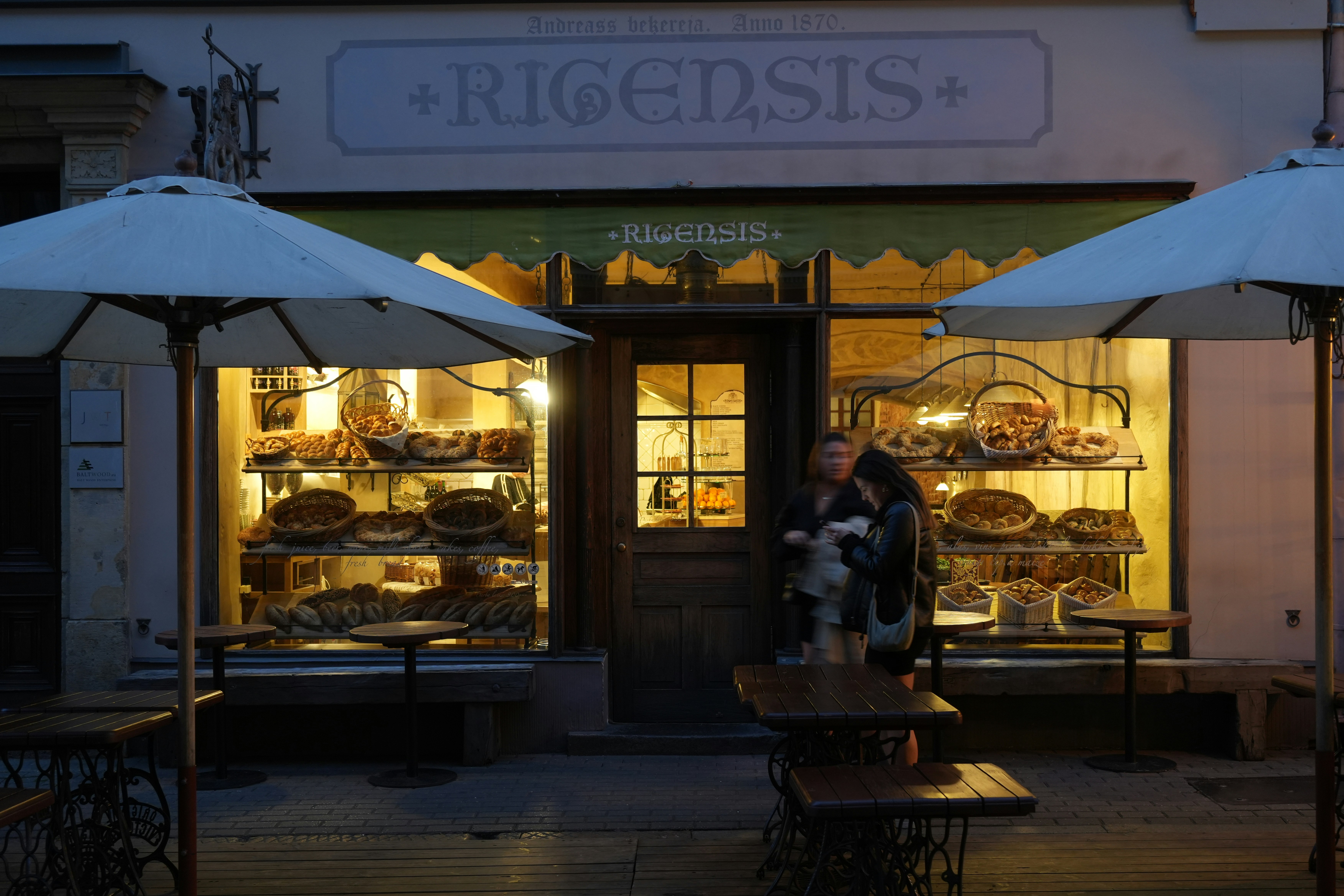A man sitting at a table in front of a bakery