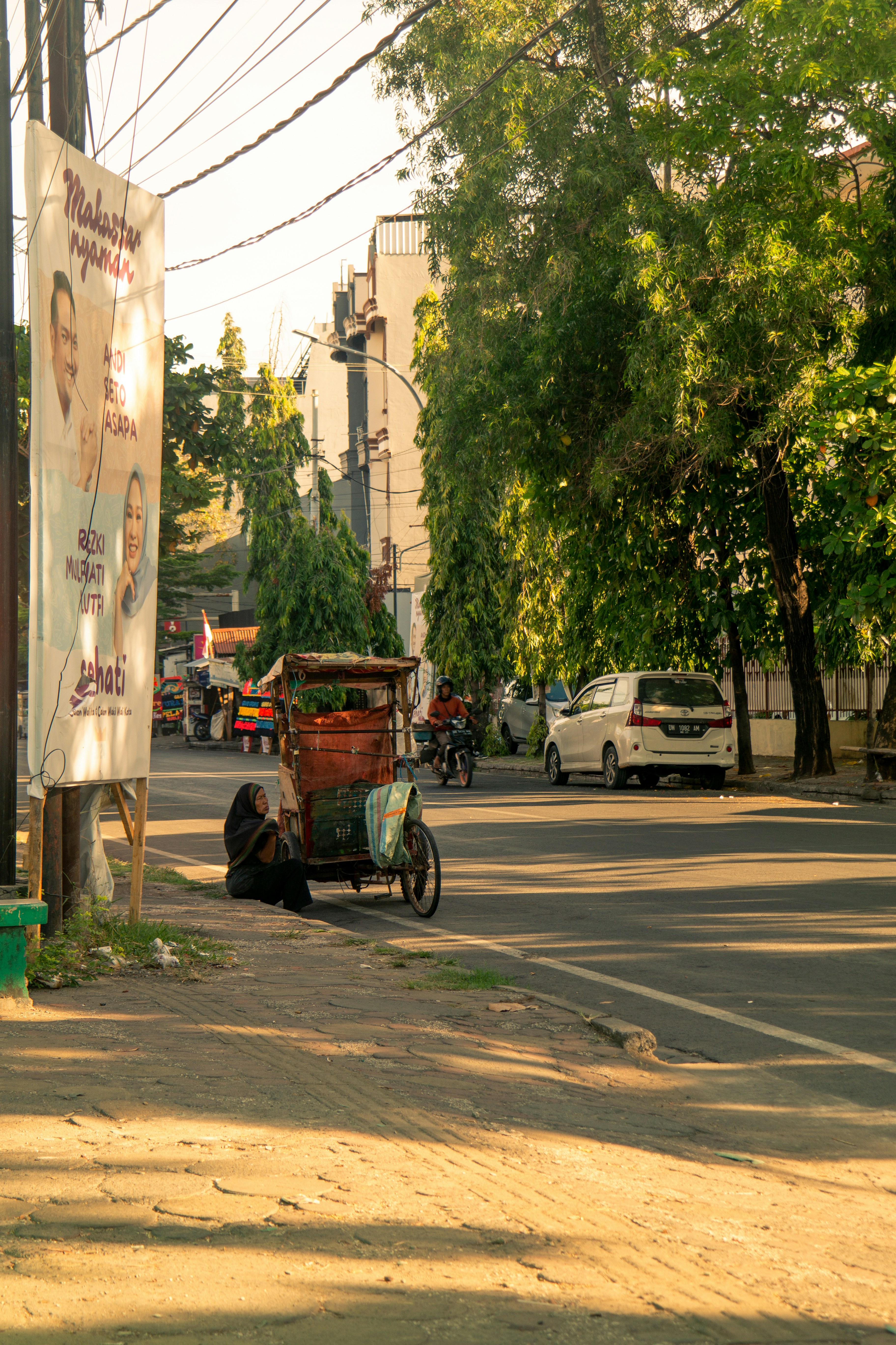 A street scene with a person sitting on the side of the road