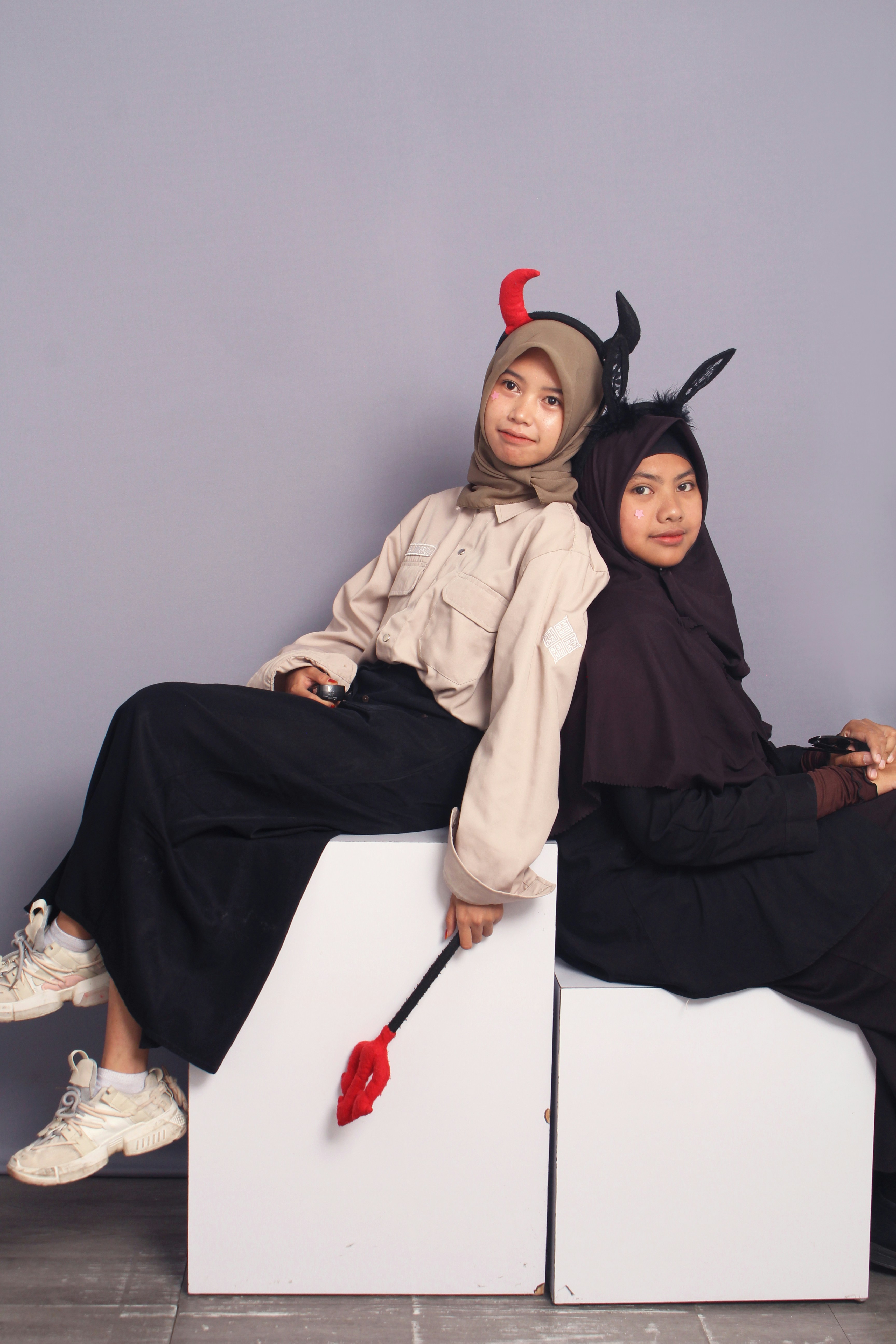 A couple of people sitting on top of a white box