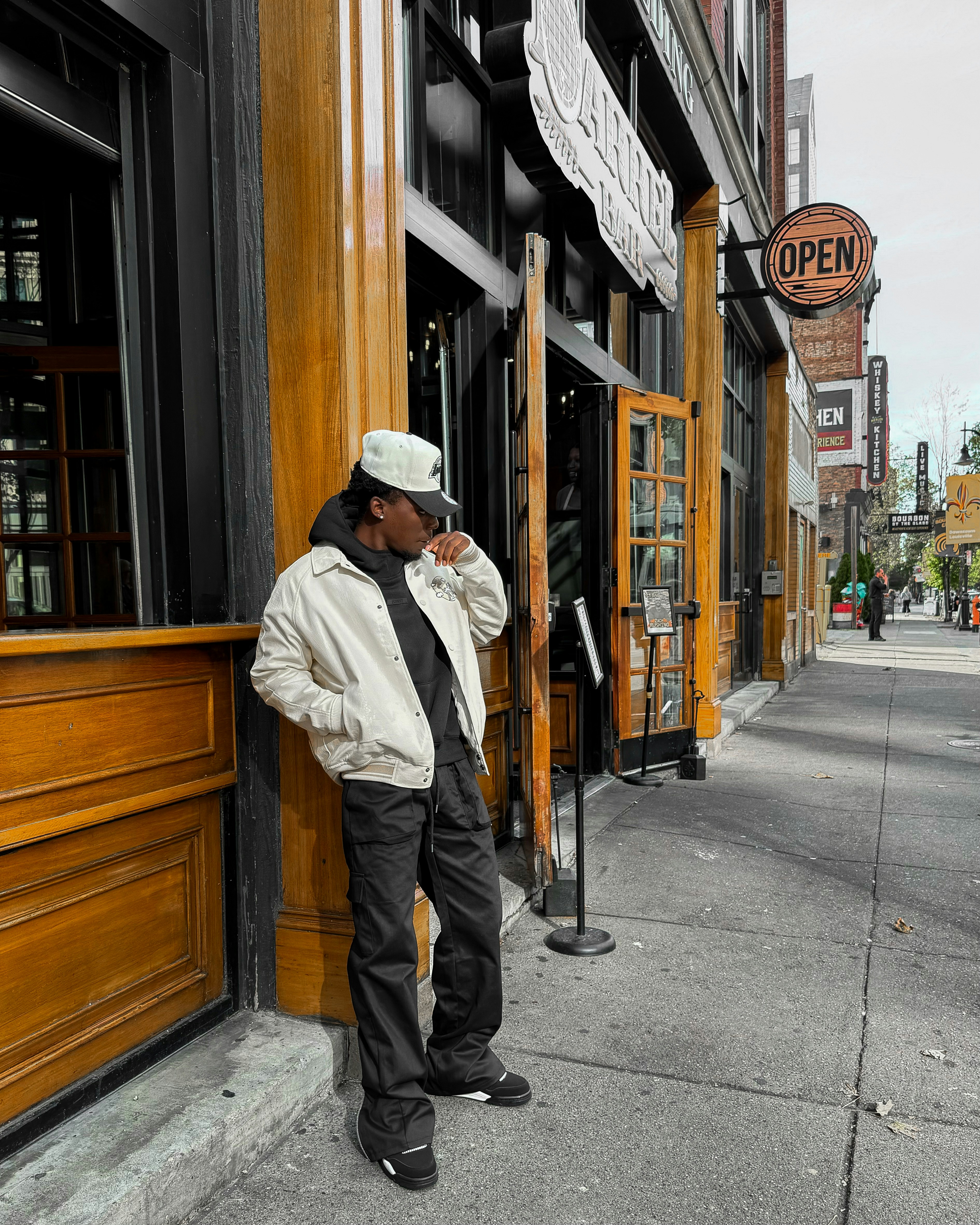 A man leaning against a building talking on a cell phone