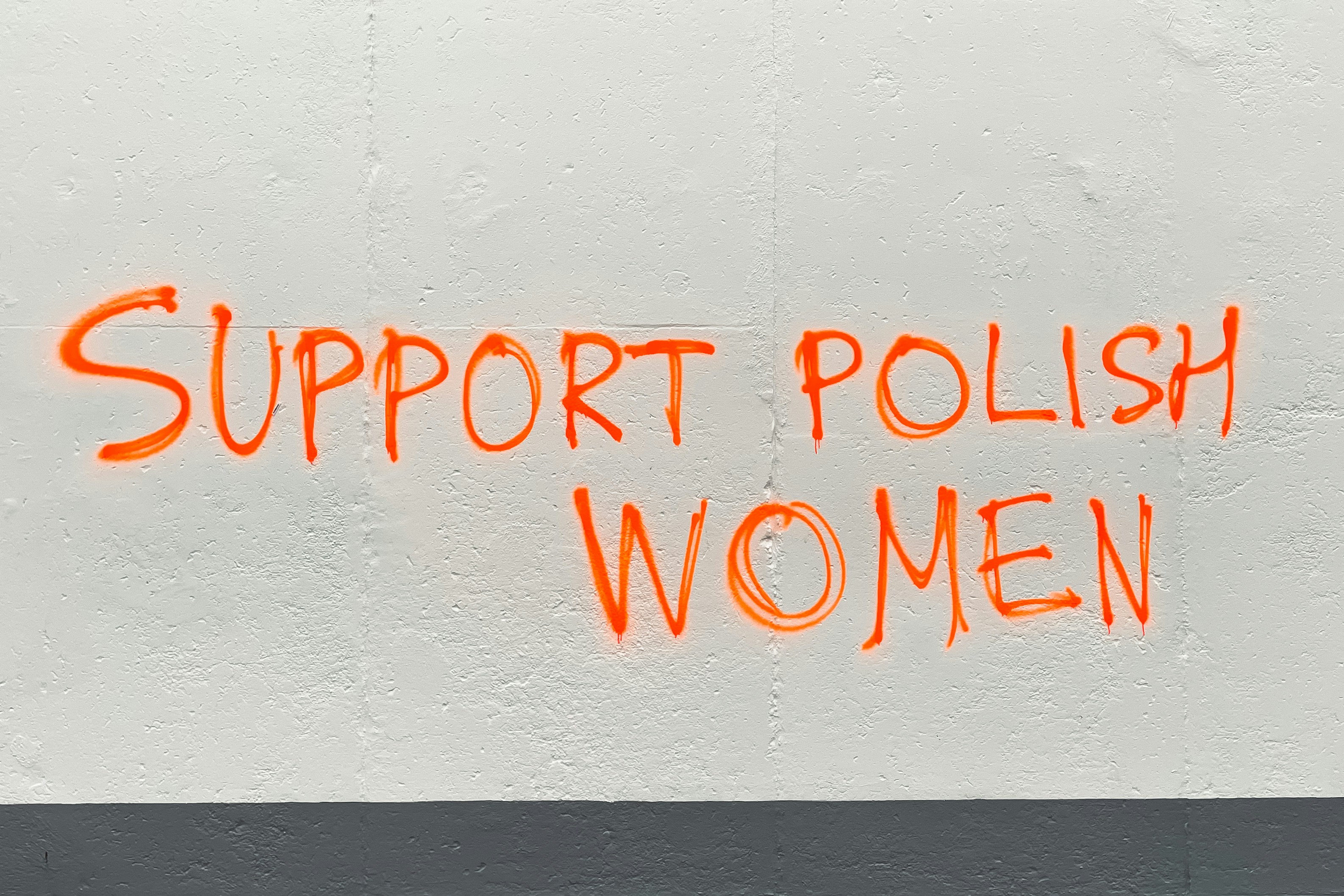 A sign that says support polish women on a wall
