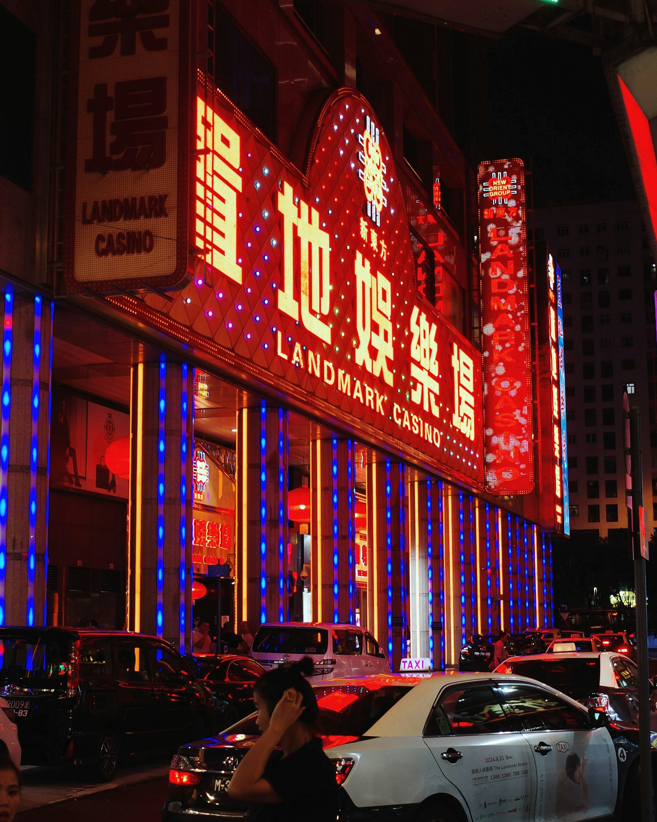 A city street filled with traffic next to tall buildings