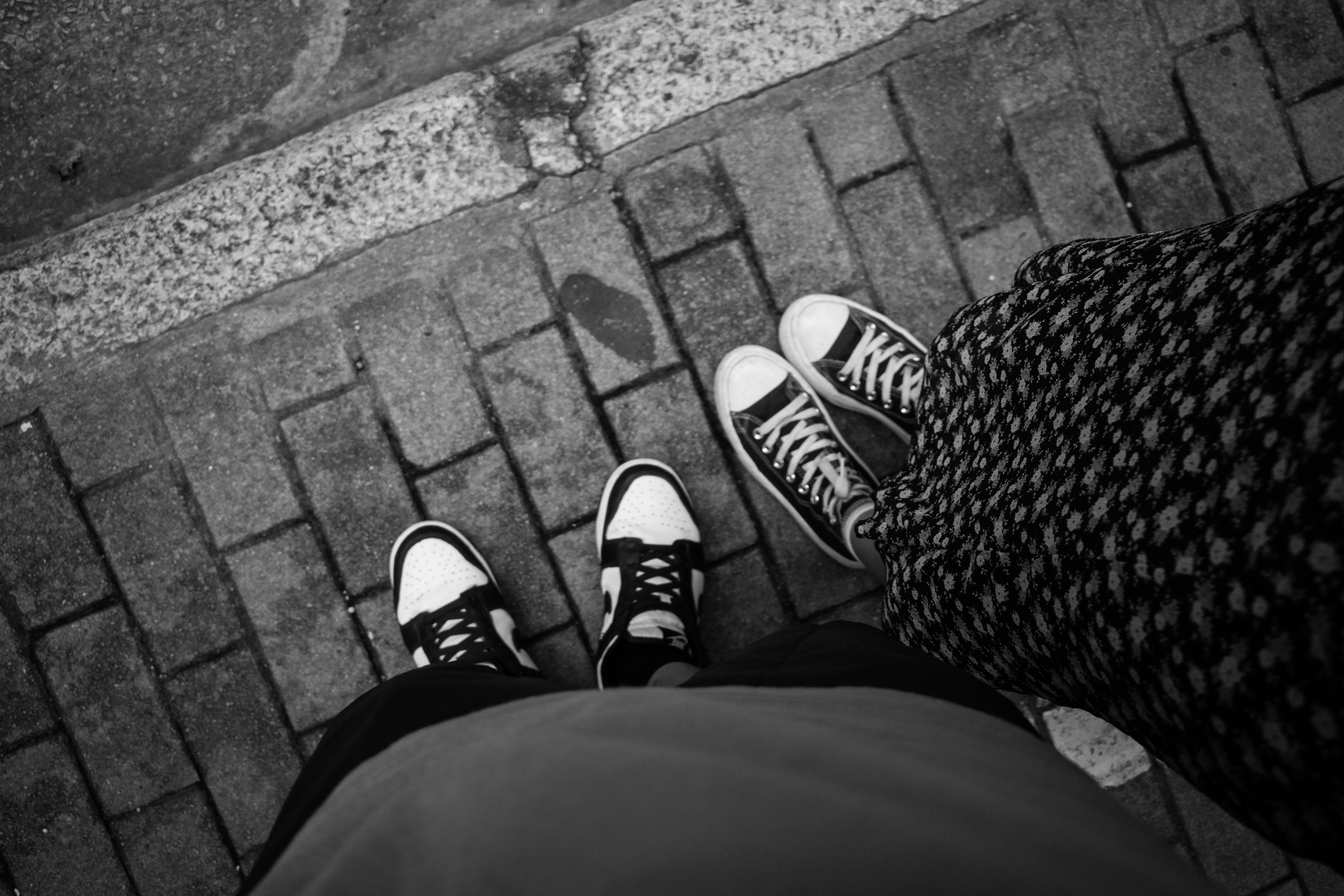 A couple of people standing on top of a sidewalk