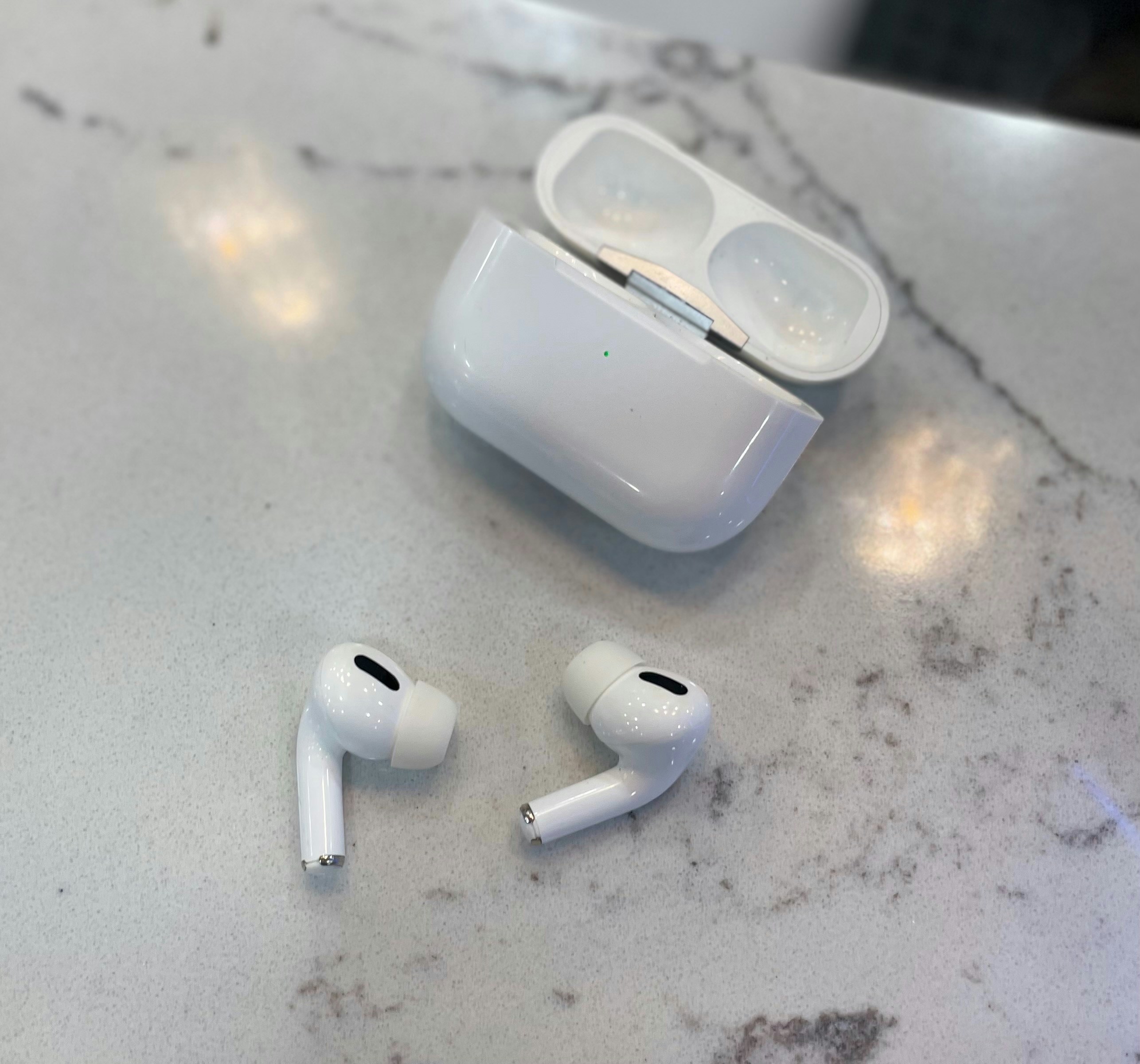 Apple AirPods Pro in white case on marble surface