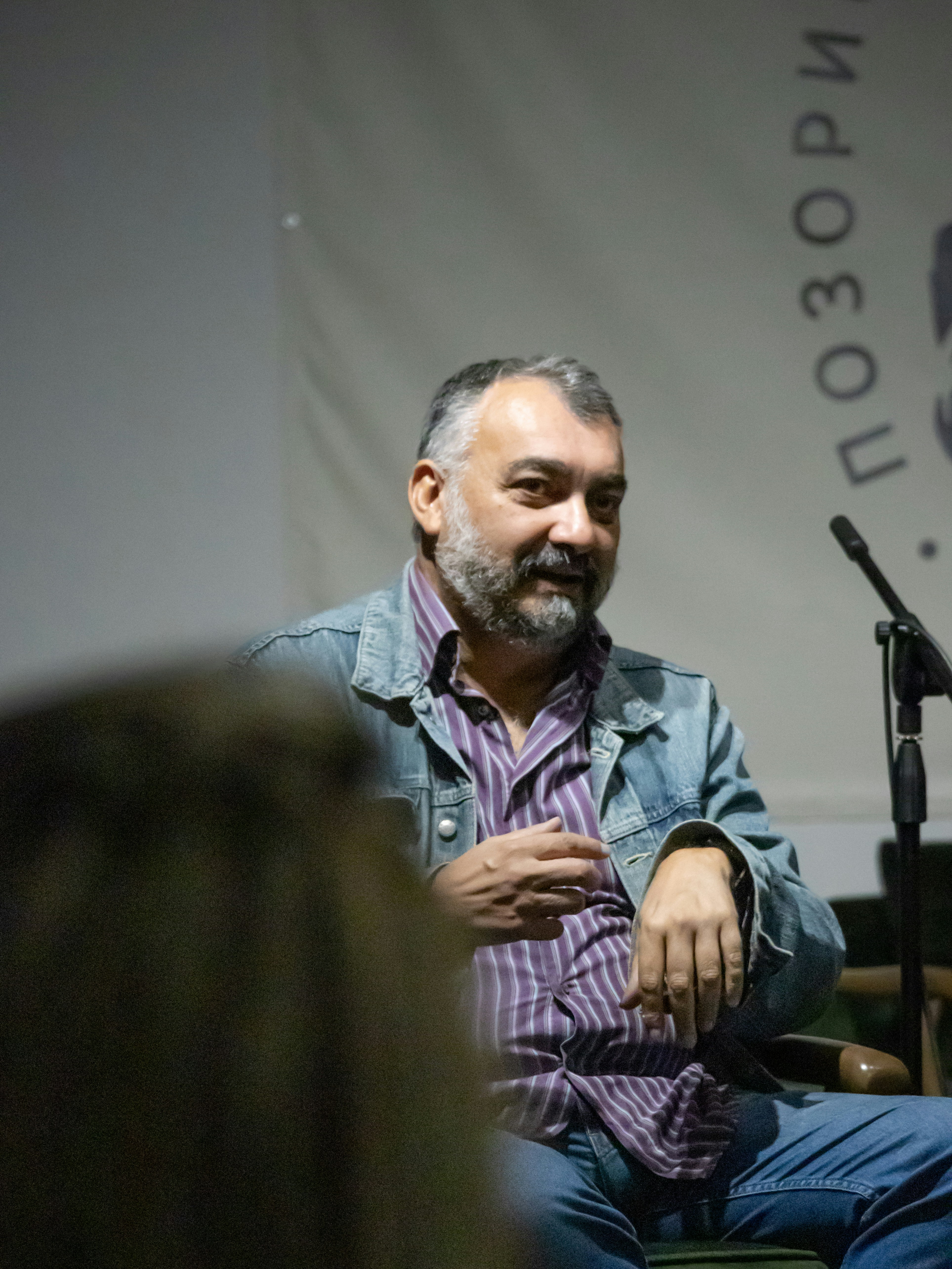 A man sitting in a chair in front of a microphone