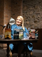 A woman sitting at a table in front of a microphone