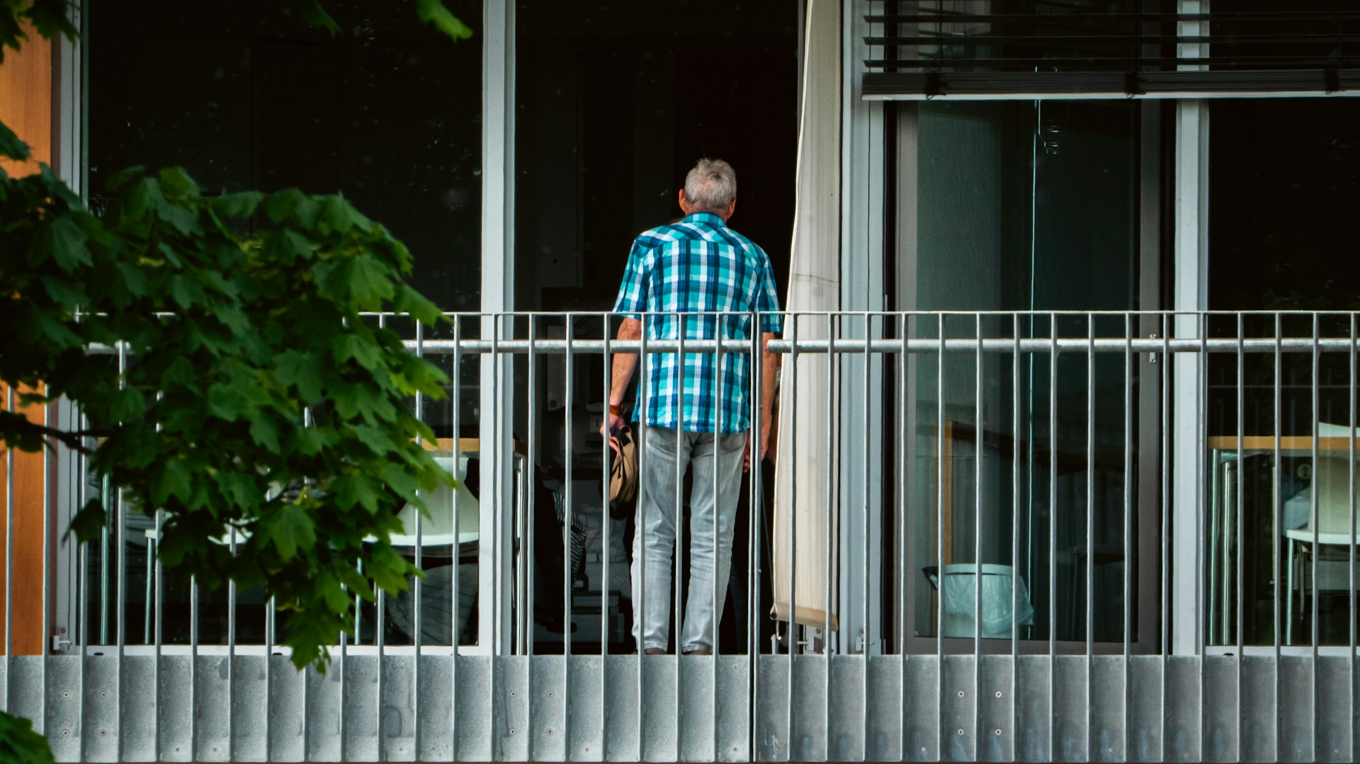 A man standing on a balcony next to a building