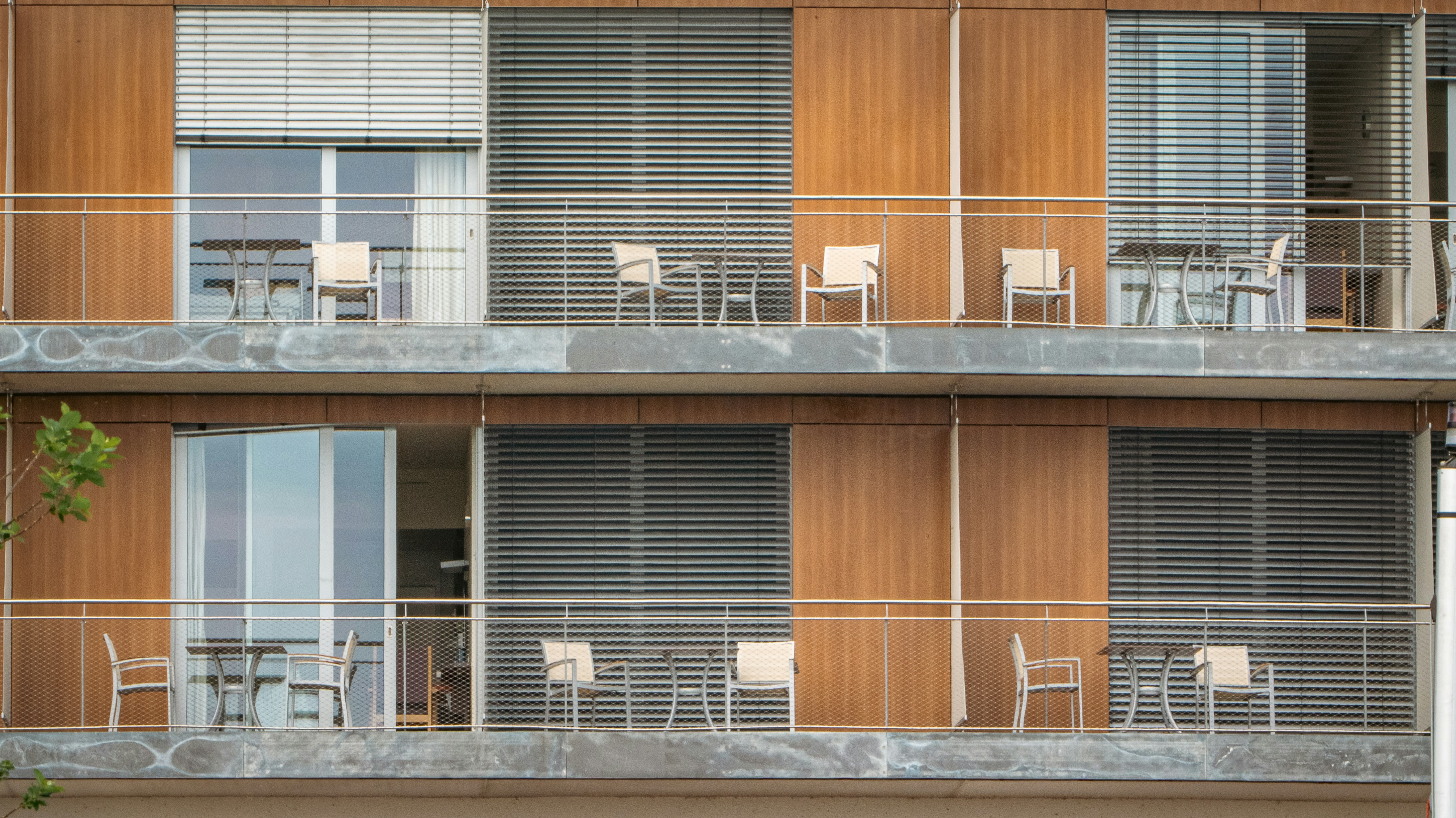 バルコニーとバルコニーに椅子がある高層ビル