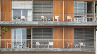 A tall building with balconies and chairs on the balconies