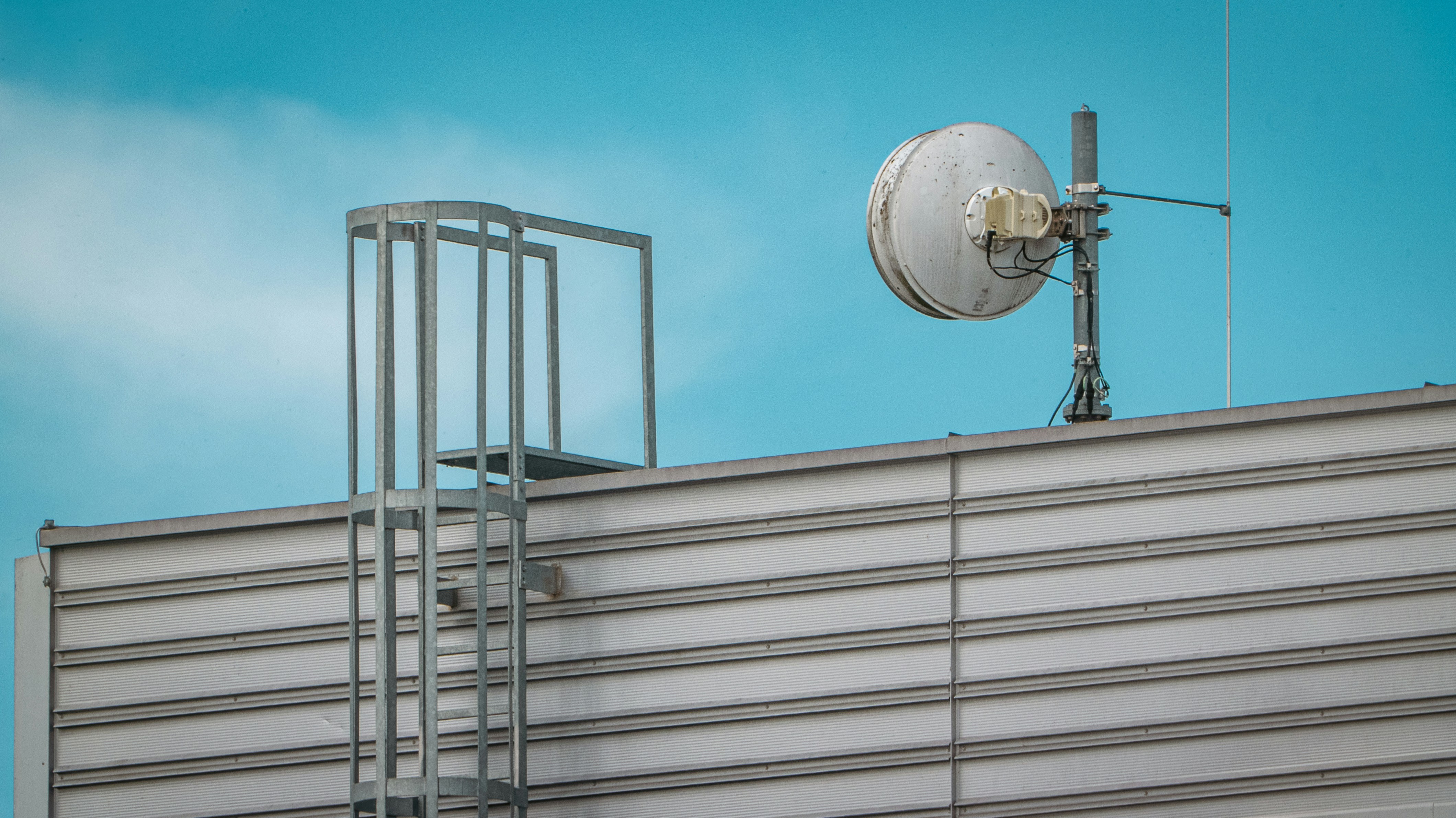 A tall building with a weather vane on top of it