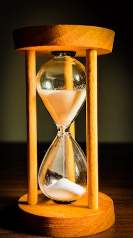 An hourglass sitting on top of a wooden table