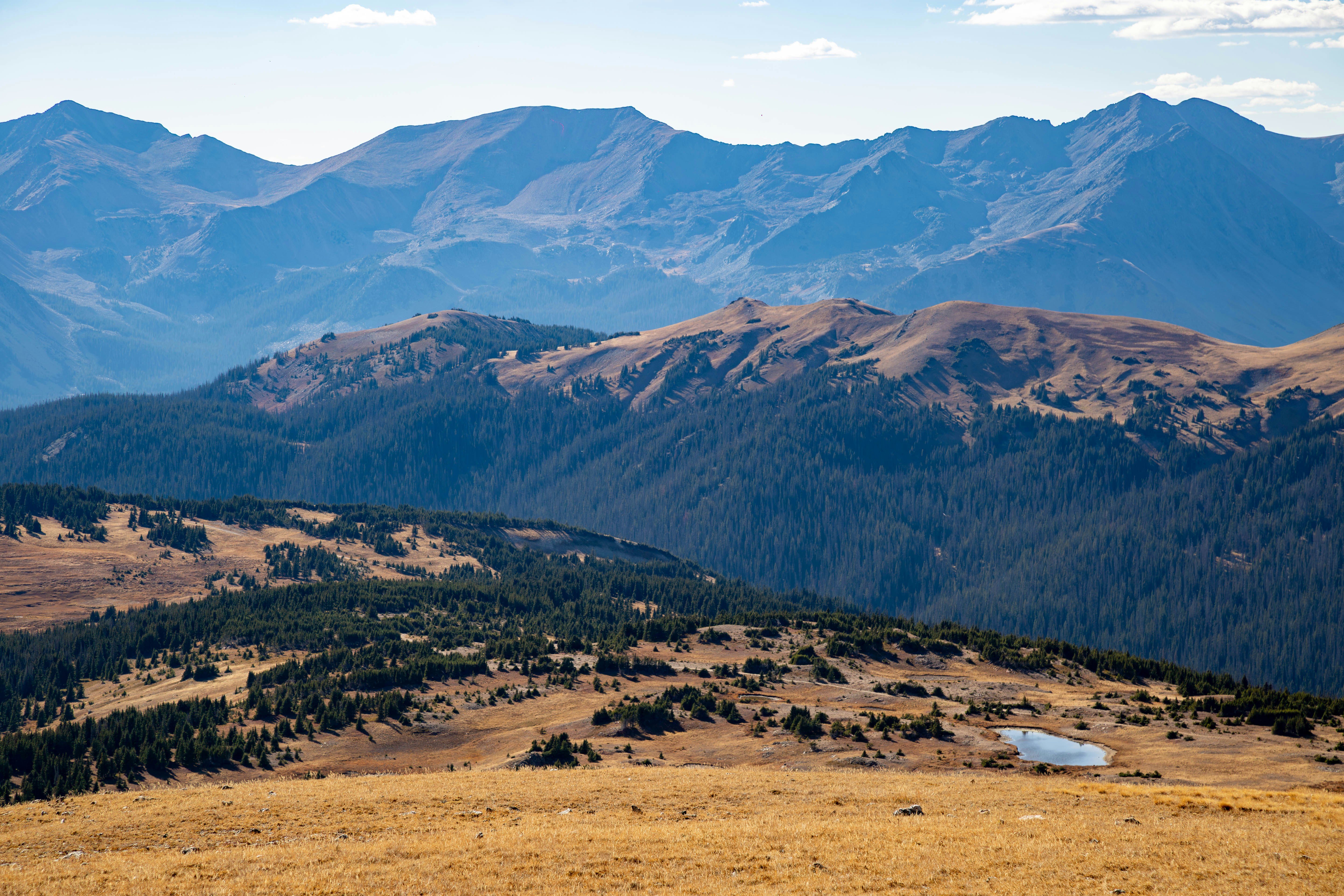 A view of a mountain range from the top of a hill