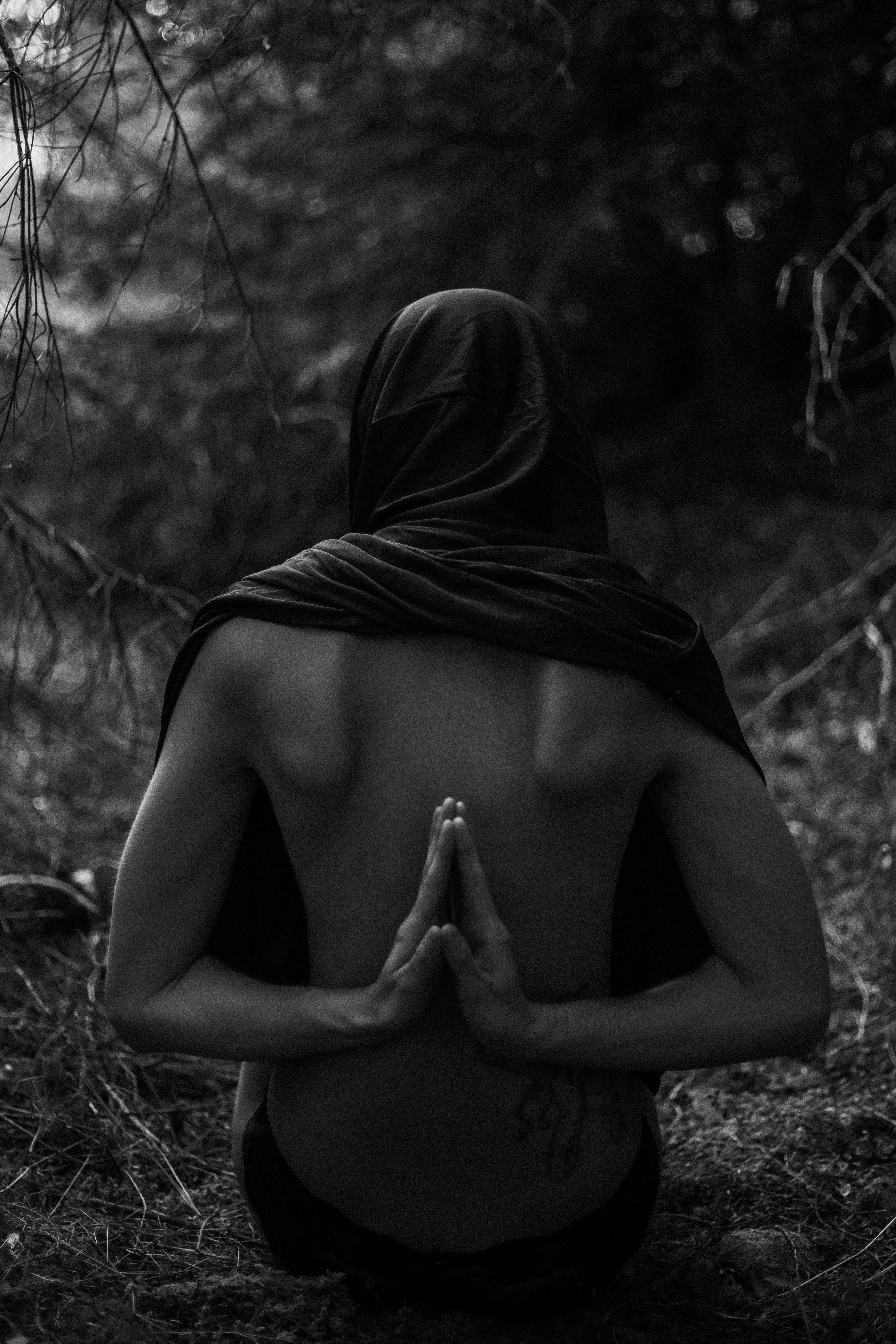 A person sitting in the woods with their back to the camera