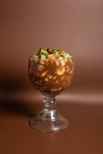 A glass filled with food sitting on top of a table