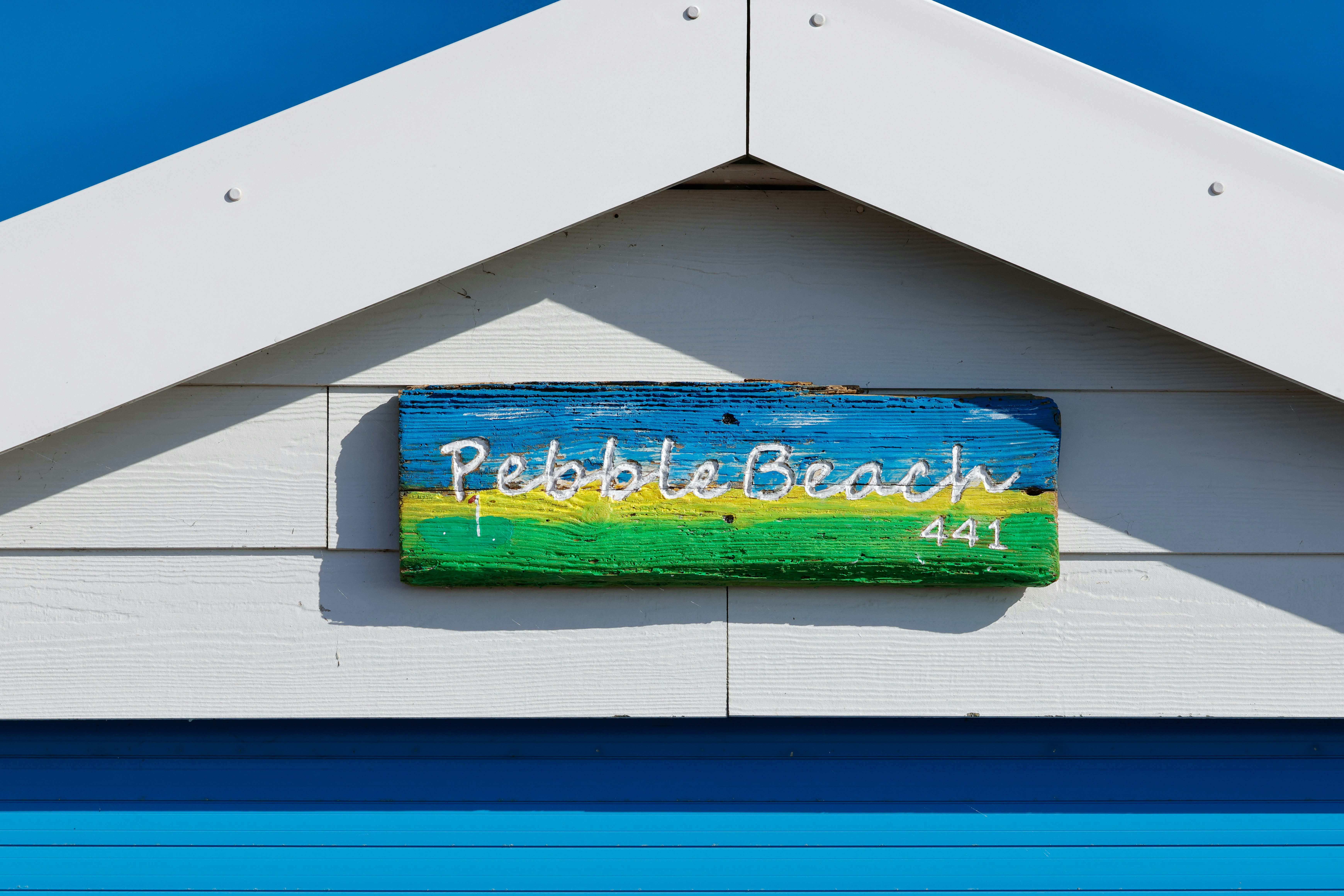 A sign on the side of a building that says pebble beach