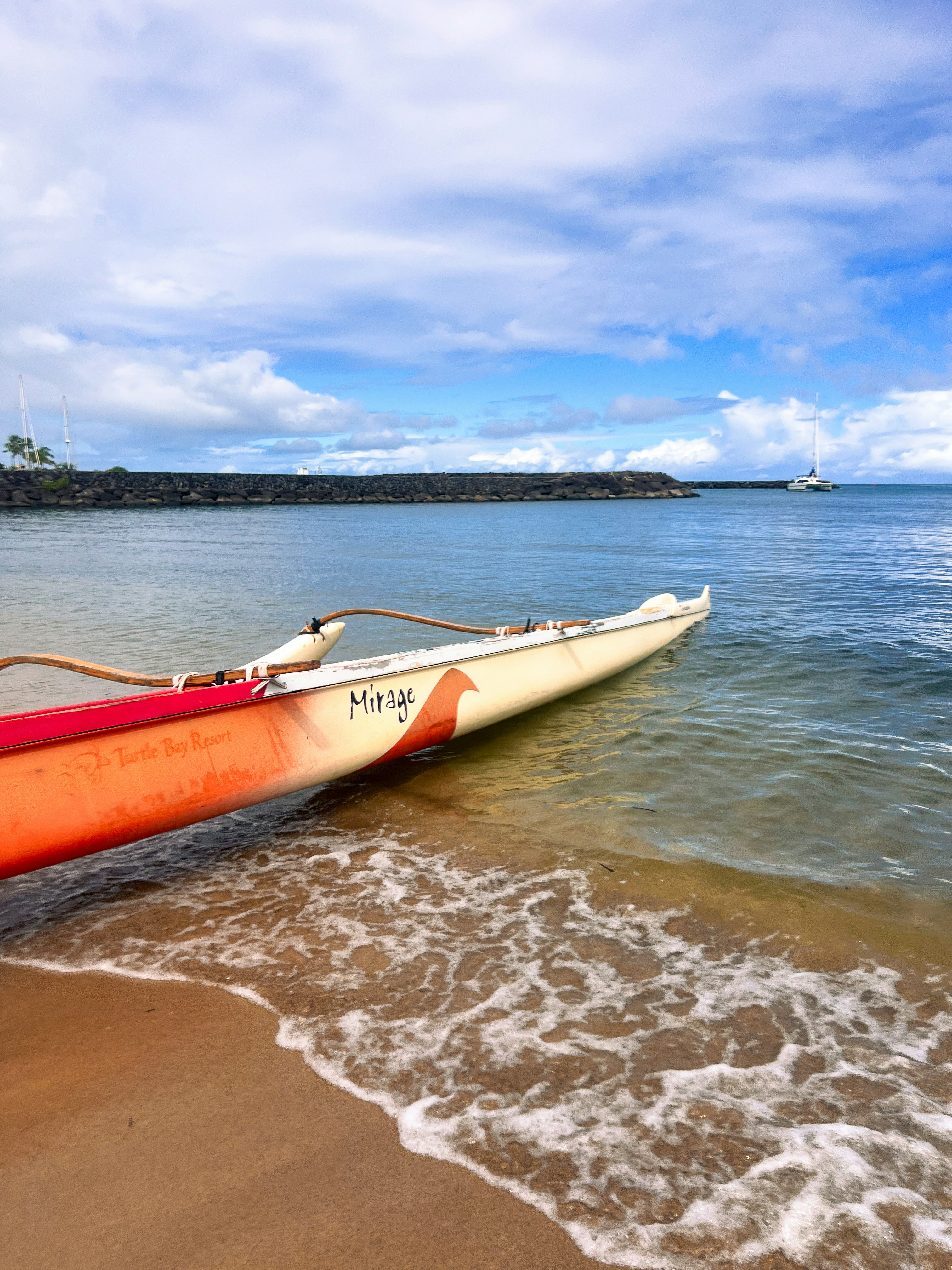 A red and white boat sitting on top of a beach