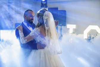 A bride and groom dancing in a cloud of smoke