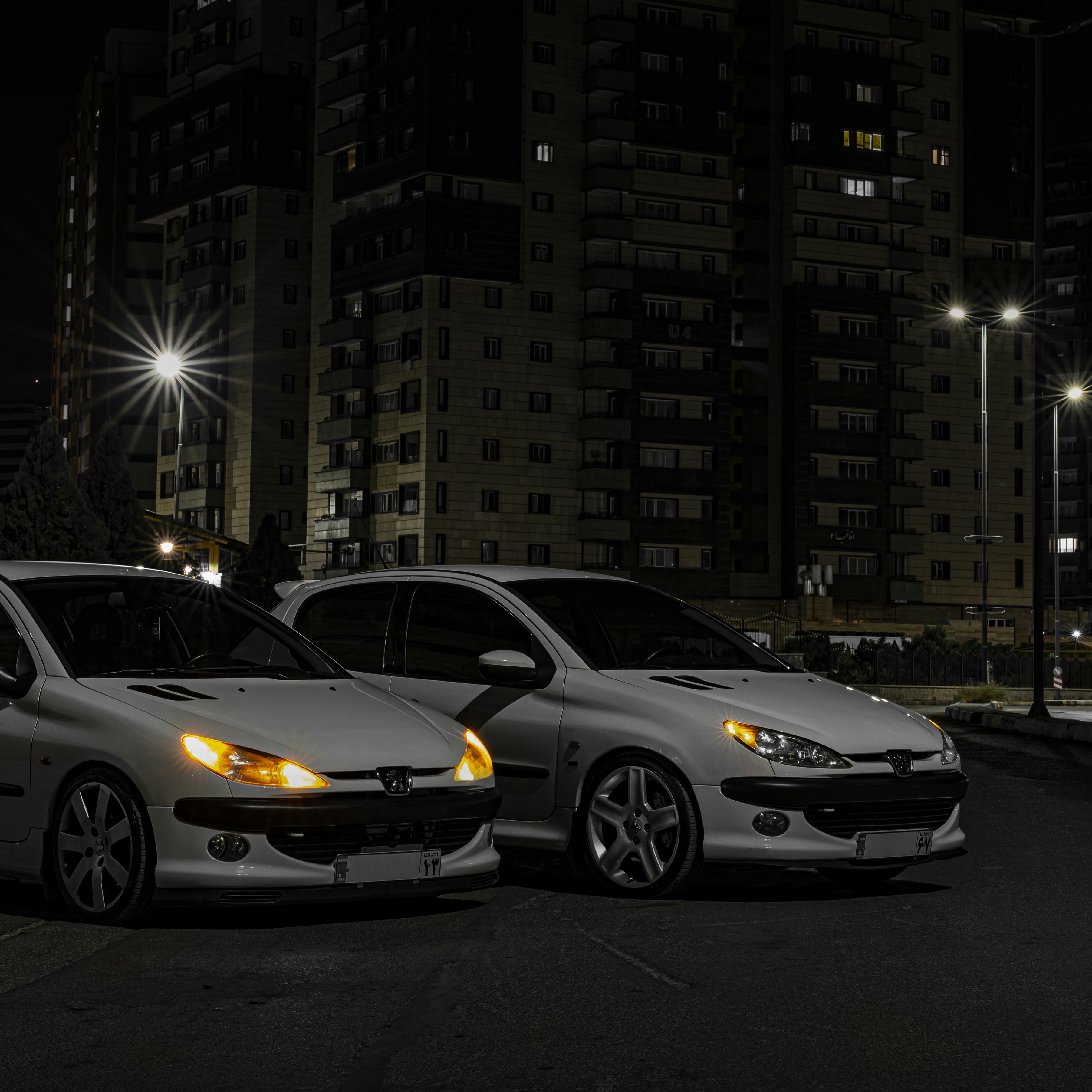 A couple of white cars parked next to each other