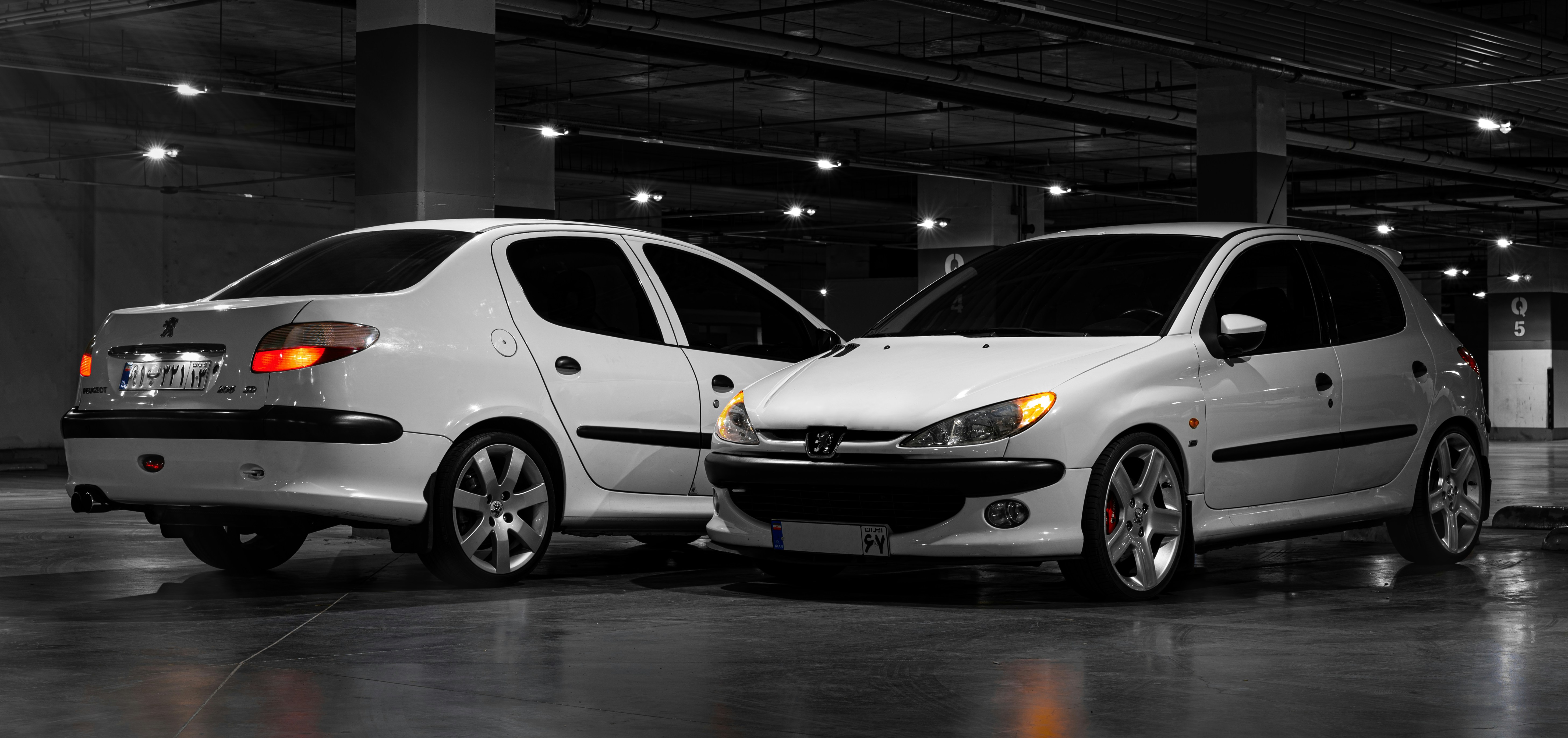 A couple of white cars parked next to each other