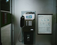 An old style pay phone in a public restroom