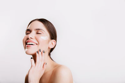 A woman smiles while she holds her hand to her face
