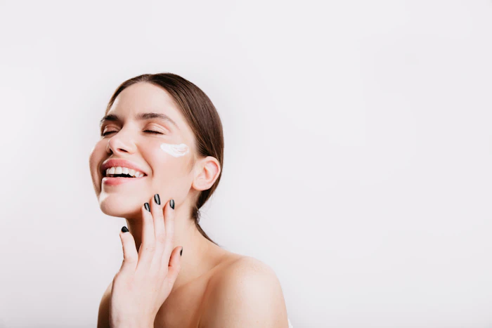 Woman applying cream and laughing (model)