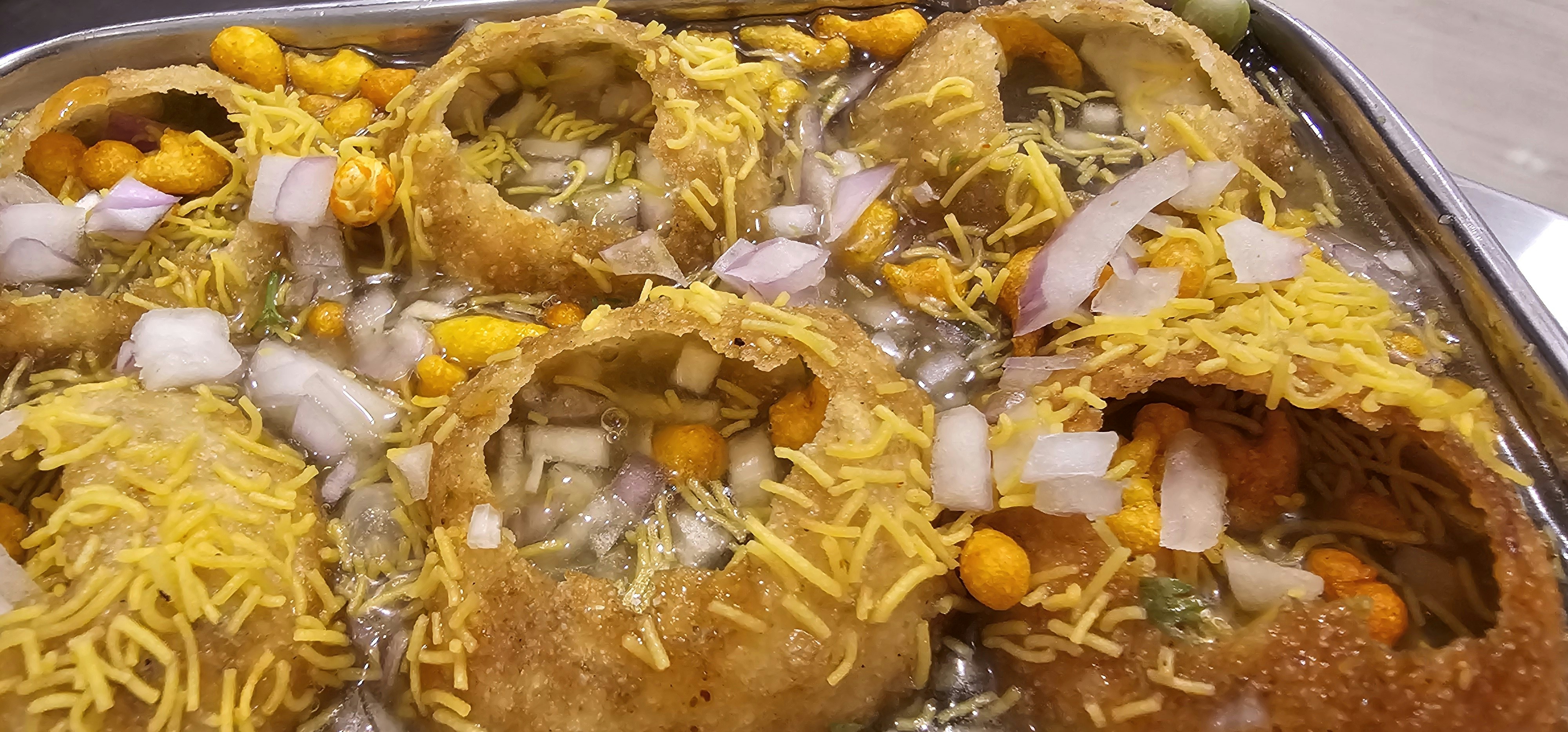 Fresh Indian street food chaat with colorful garnishes, bright daylight photography