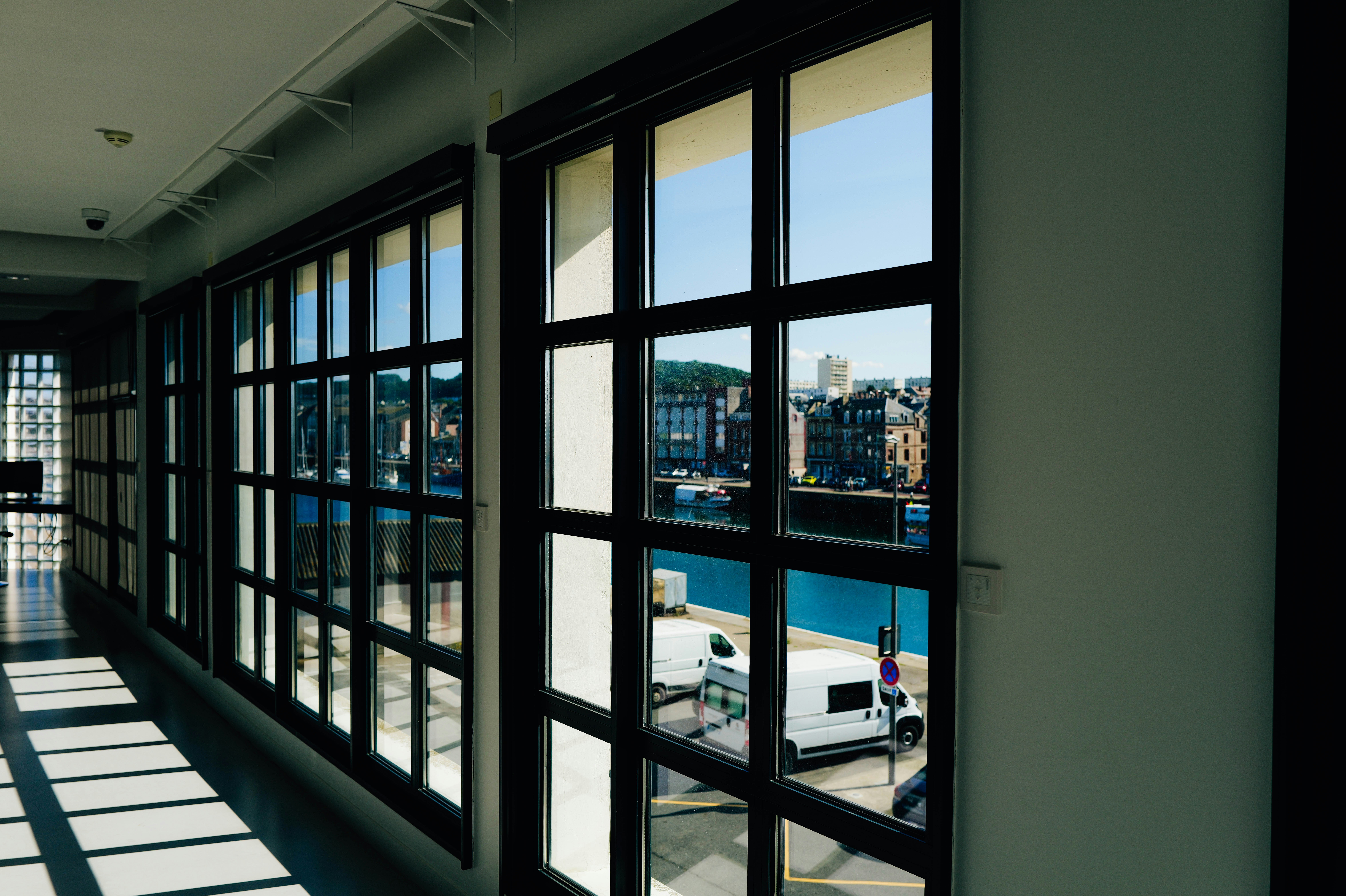 A long hallway with lots of windows and a view of a city