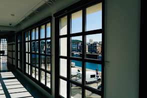 A long hallway with lots of windows and a view of a city