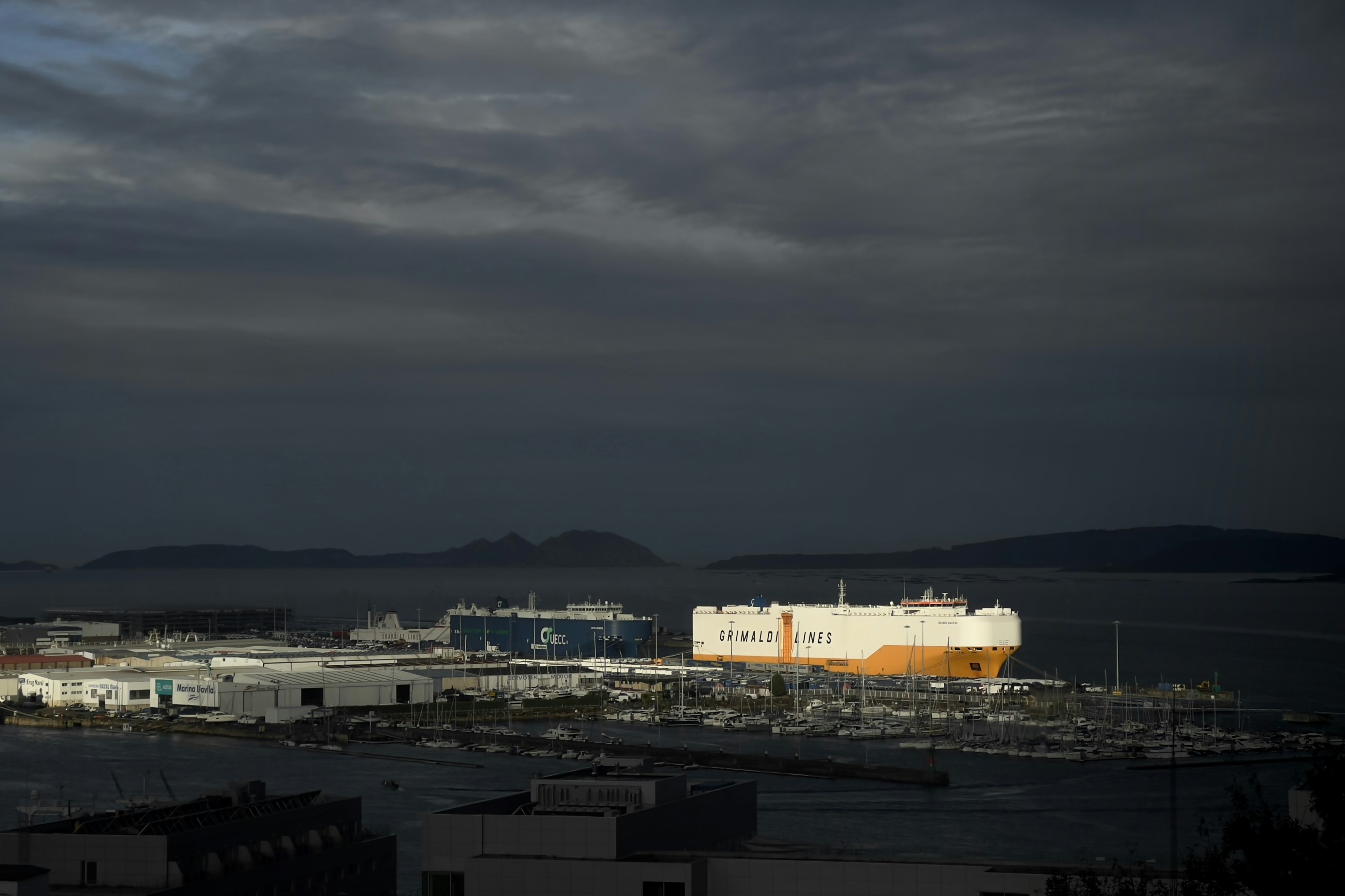 A cloudy sky over a city with buildings and a body of water