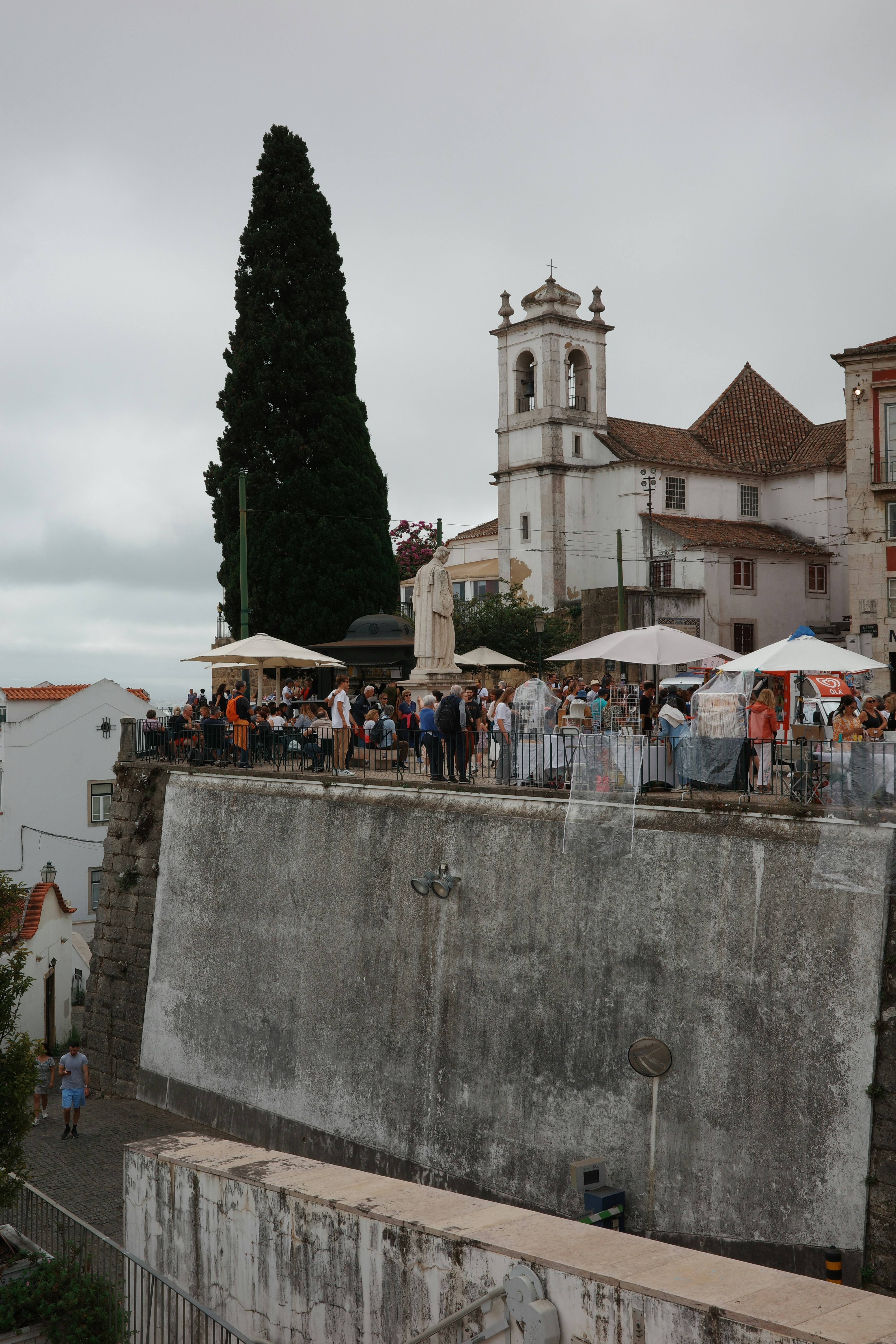 A group of people standing on top of a cement wall