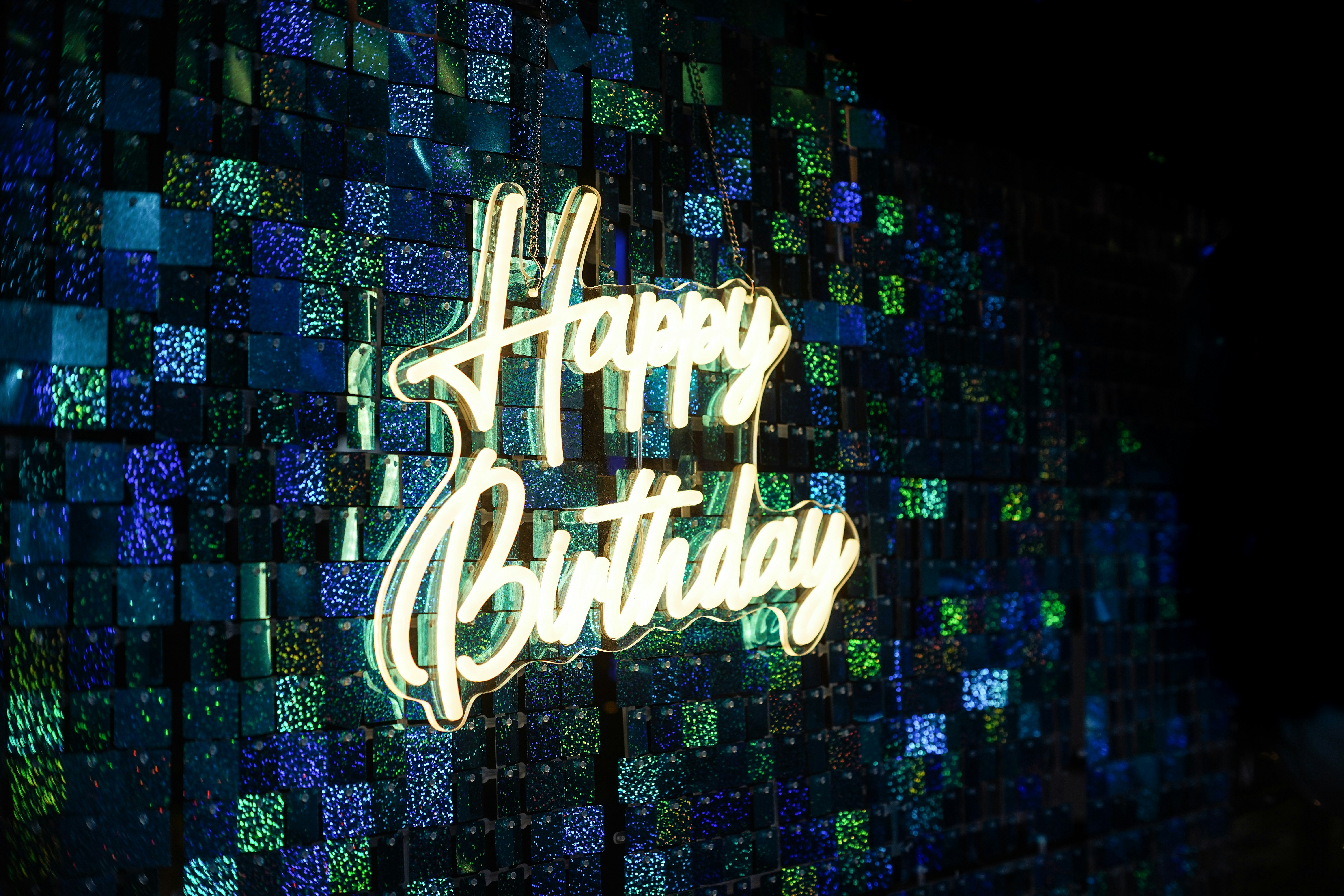 A happy birthday sign is lit up on a wall