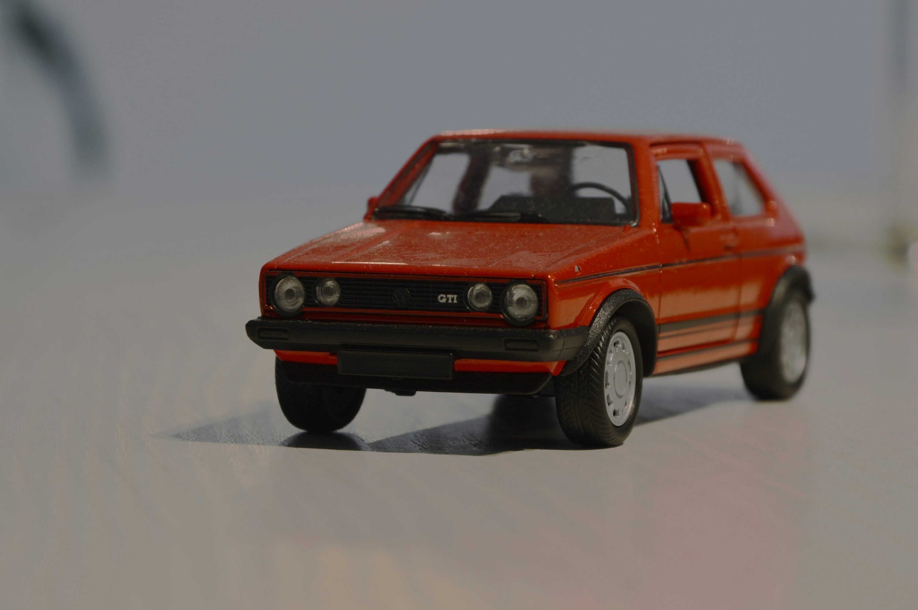 A red toy car on a white surface