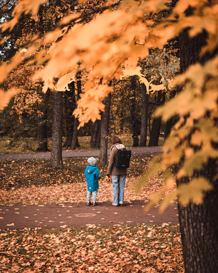A man and a child walking through a park