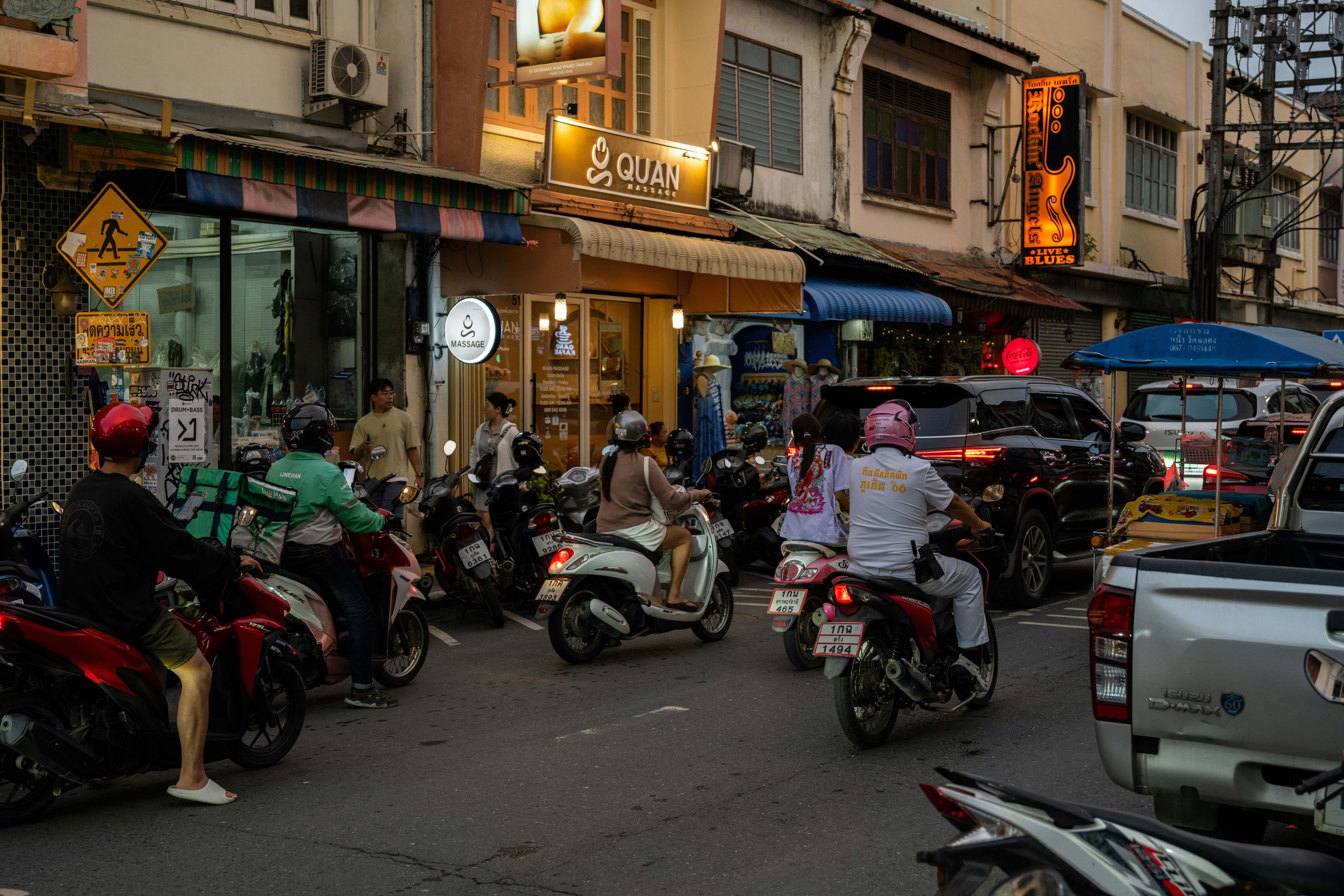 A group of people riding motorcycles down a street