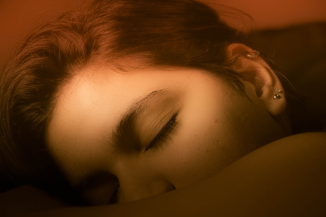 A woman sleeping on a bed with her eyes closed,
