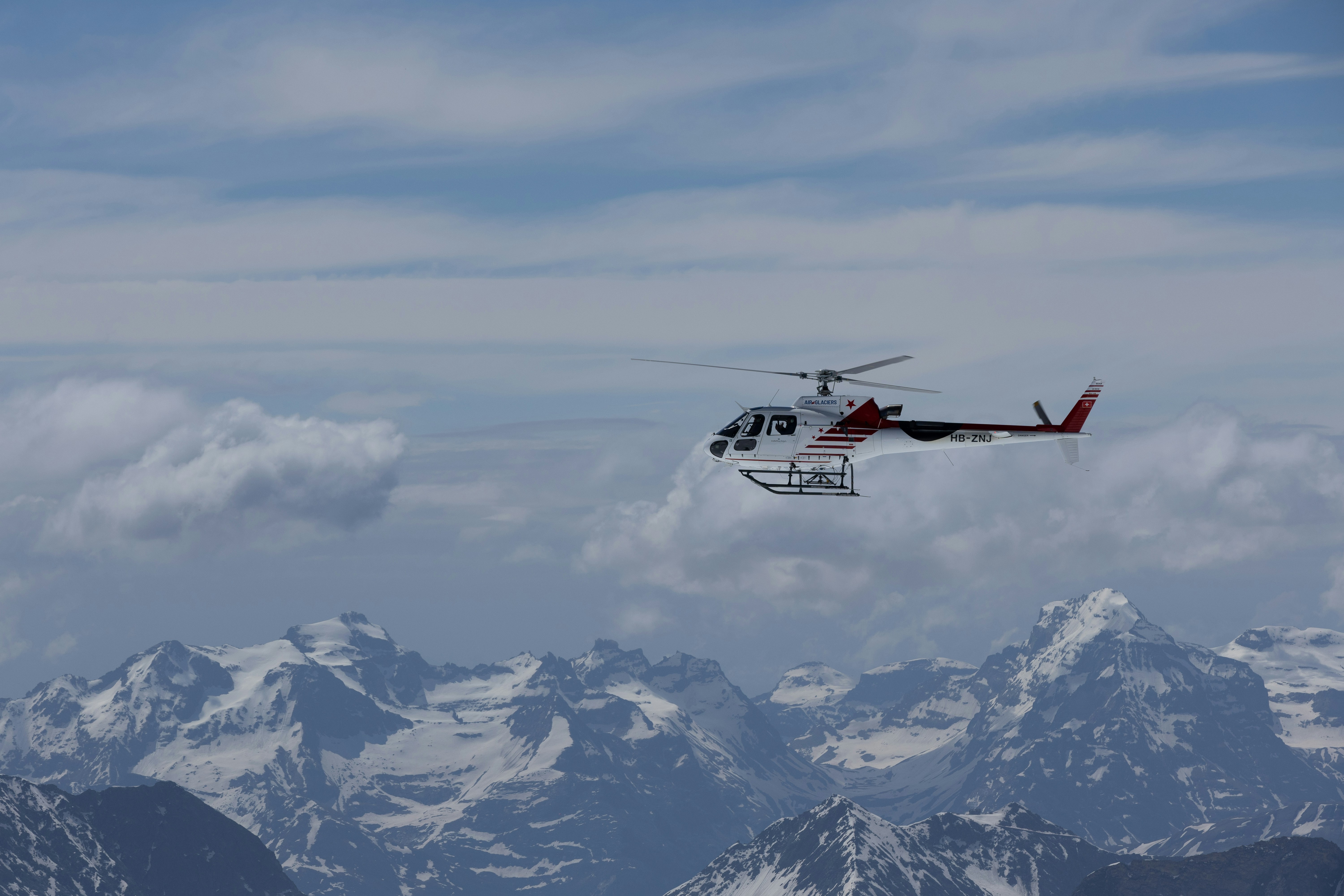 A helicopter is flying over a mountain range